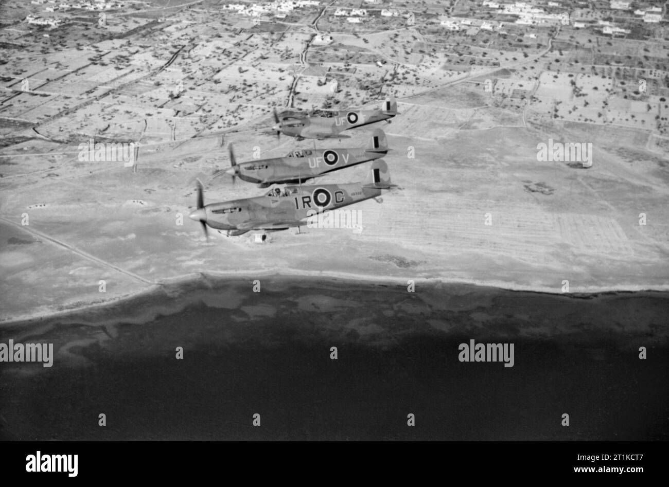 Spitfire LF Mk vs de l'aile n° 244 survolant la côte tunisienne après avoir accompagné des bombardiers légers sur une sortie à Mareth, le 23 mars 1943. Trois Spitfire LF Mark VBS de l'aile n° 244 RAF basée à BU Grara, volant dans une formation d'échelon à tribord au large de la côte tunisienne après avoir accompagné des bombardiers légers sur une sortie à Mareth. La caméra la plus proche est AB502 ?IR-G?, l'avion personnel du chef de l'aile, commandant de l'aile I 'Widge' Gleed, qu'il a volé quand il a été abattu et tué au-dessus de Cap bon le 16 avril 1943, alors que les deux avions d'accompagnement sont ER220 ?UF-V? ET EP481 ?UF-F ? De l'escadron n° 601 R Banque D'Images
