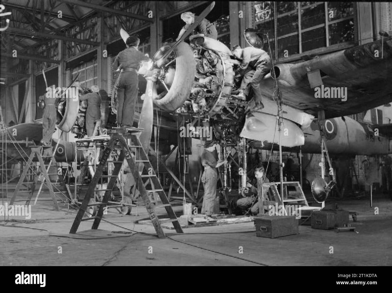 Les femmes sur le front intérieur, 1939 - 1945, la Women's Auxiliary Air Force (WAAF) : RAF et WAAF mécanique de vol de travailler ensemble sur un Bristol Beaufighter Mark VI dans un hangar de maintenance n° 51 L'unité de formation opérationnelle, Cranfield, Bedfordshire. Ils sont illustrés de régler le châssis, travaillant sur l'hélice et d'effectuer une inspection du moteur. Banque D'Images