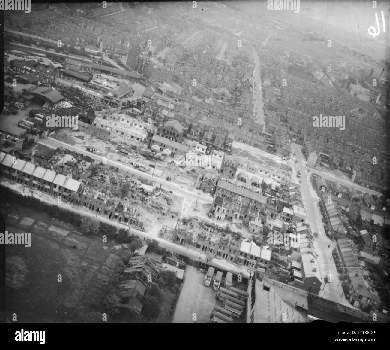 Dommages à la bombe à Londres, en Angleterre, avril 1945 Vue aérienne de l'ouest du dommage résultant d'un V2 rocket missile qui a explosé dans la région de Boleyn et Prieuré de routes, Upton Park, East Ham, London E6, en Angleterre, à 10h30 le 28 janvier 1945. Seize personnes ont été tués, vingt-sept blessés graves et soixante-neuf légèrement blessé. 5 maisons ont été complètement détruites, 16 partiellement démolies et 59 autres ont été gravement endommagées. Certaines maisons endommagées sur prieuré et Seymour routes ont été re-couvert/e (premier plan et en bas à droite), et l'utilité du logement a été érigée à Clèves route sur sol cle Banque D'Images