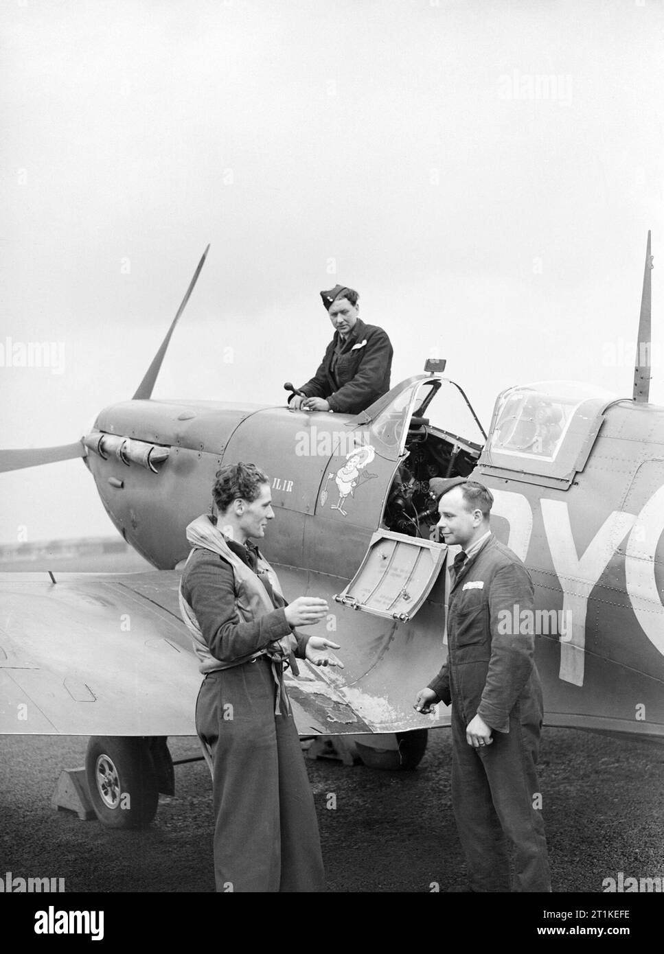 Un pilote tchèque Spitfire Karel Vykoukal de l'escadron n° 313, en conversation avec son régleur et son monteur à Hornchurch, le 8 avril 1942. Un pilote tchèque Spitfire Karel Vykoukal de l'escadron n° 313, en conversation avec son mécanicien et son entreprise d'aménagement à Hornchurch, le 8 avril 1942. Son avion est le BL581 Moesi-llir, un Mk VB présenté par le Fonds des Indes néerlandaises. Banque D'Images