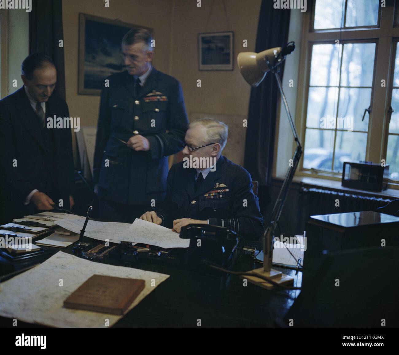 La Royal Air Force pendant la Seconde Guerre mondiale personnalités- l'Air Chief Marshal Sir Arthur Harris T, commandant en chef du Royal Air Force Bomber Command, discuter d'une coopération avec l'officier d'état-major de l'air principal, Vice-maréchal de l'Air R D Oxland, CB, CBE, et M. M T Spence, OBE. Banque D'Images