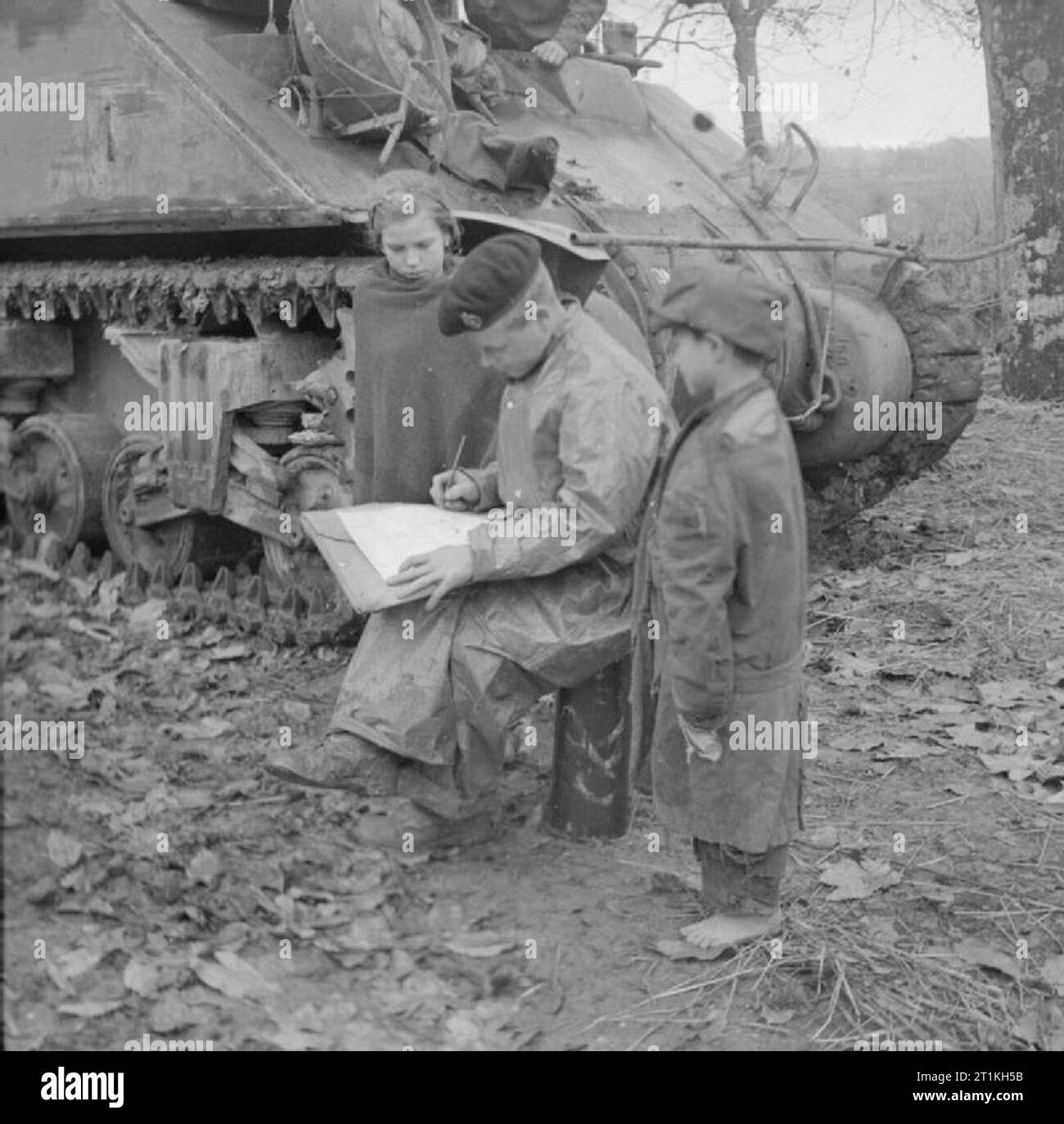 L'Armée britannique en Italie 1943 enfants regarder un Sherman tank crewman écrit une carte de Noël, 17 novembre 1943. Banque D'Images