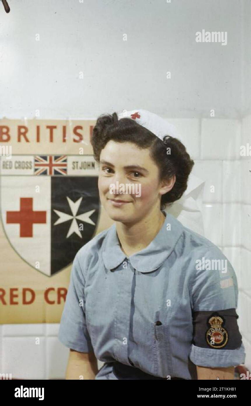 Les femmes en guerre 1939 - 1945 : Soins infirmiers Infirmière de demi-longueur de la Diana Hotham, détachement d'aide volontaire (VAD) en Italie. Dans l'arrière-plan est une affiche de la Croix-Rouge britannique. Banque D'Images