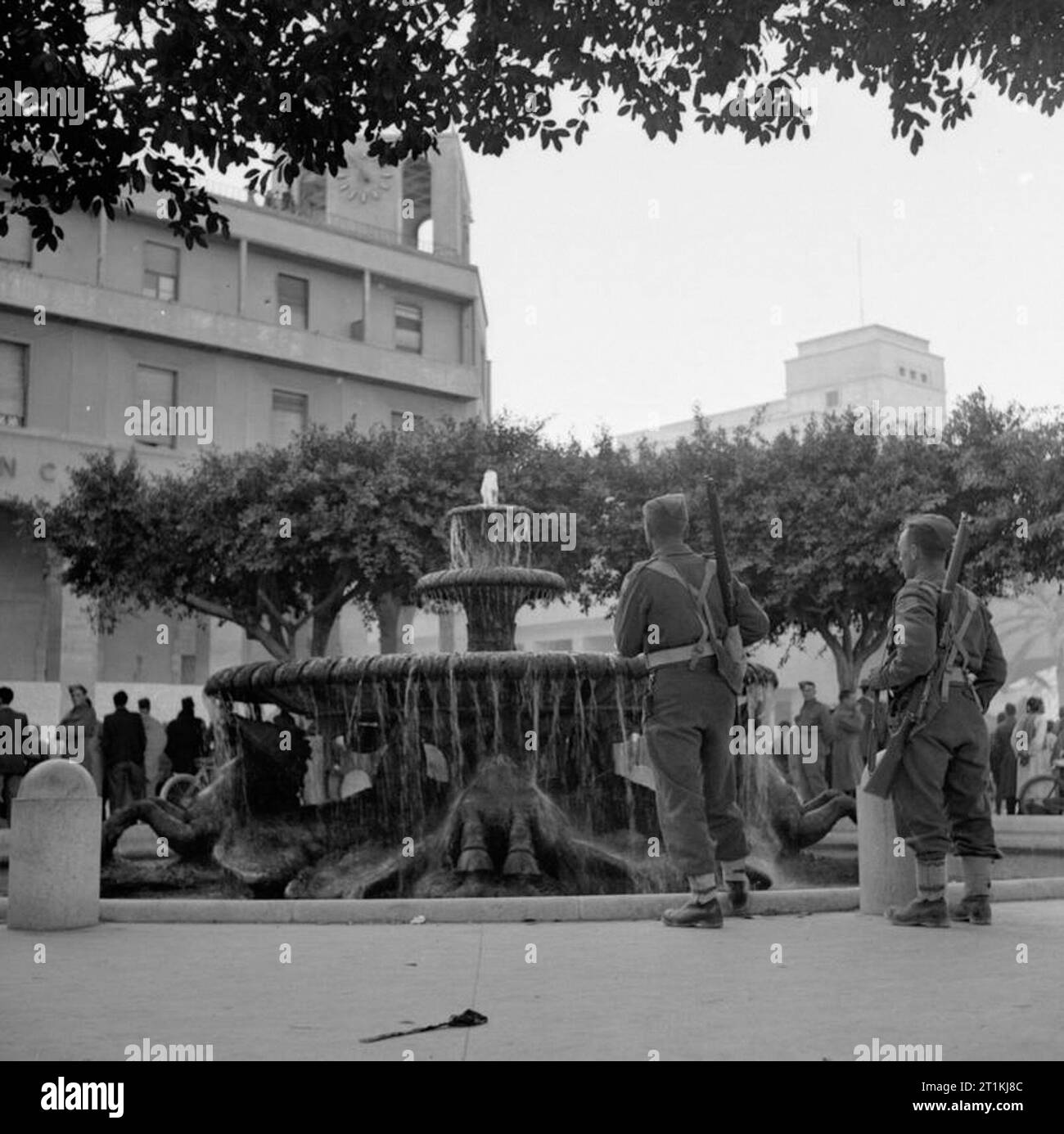 8 e armée entre dans Tripoli Tripoli est tombé à la 8e armée victorieuse. Cette marque, non seulement le triomphe de d'une campagne électorale, mais la liquidation définitive de l'Afrique de l'éloge de Mussolini Empire. Cette image montre la Tommies à la fontaine de la place principale de Tripoli. Banque D'Images