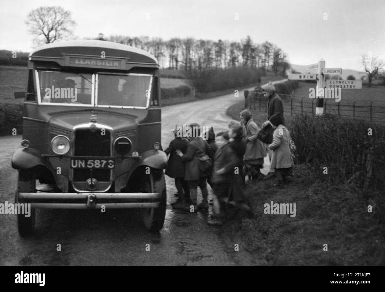 Bus Pays- Voyages et transports à Oswestry, Shropshire, Angleterre, RU, 1944 à 8:30 am tous les jours, un groupe d'enfants attendent à la croisée des chemins dans un chemin de campagne à bord du bus de pays qui les prendra à l'école du village à Llansilin, juste à la frontière du pays de Galles. Les enfants sont dans les fermes et hameaux de la région de Oswestry. Banque D'Images