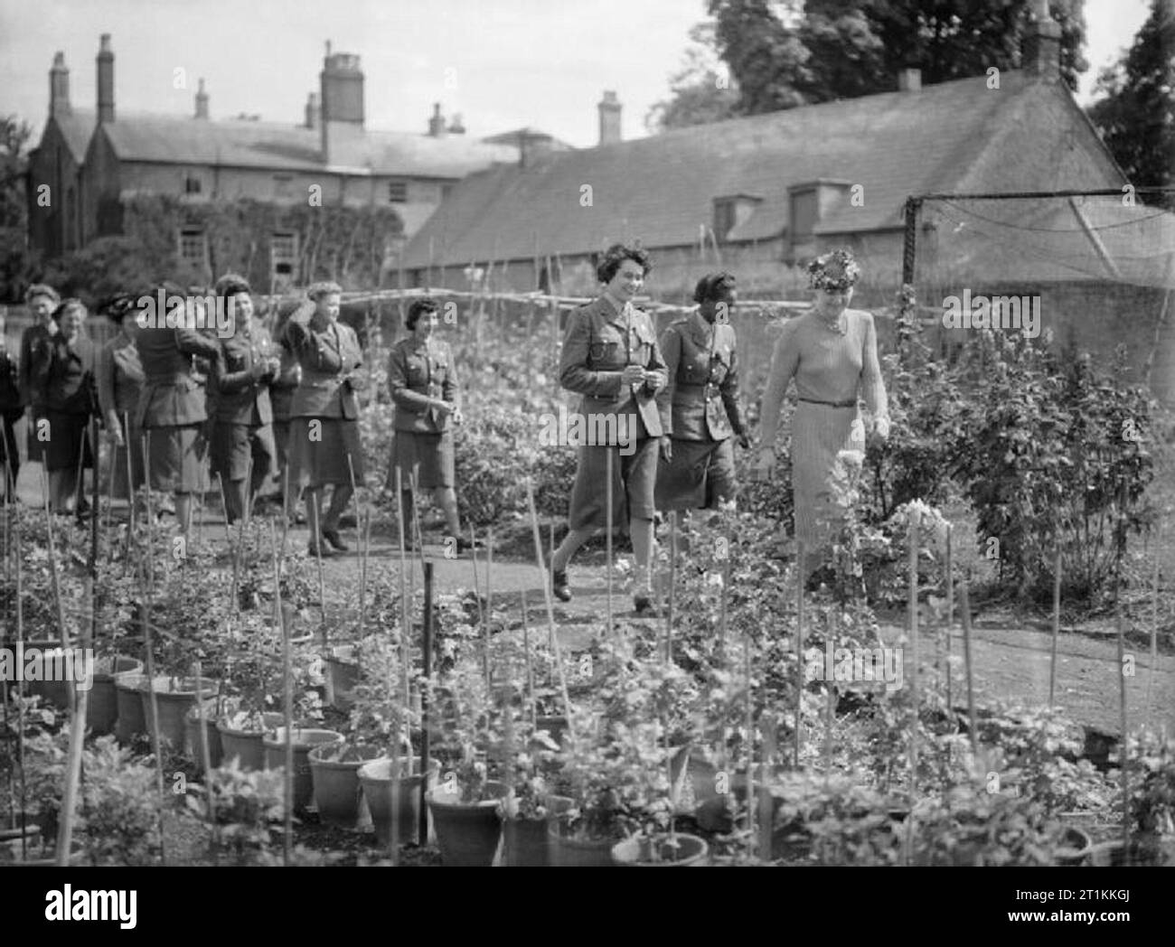 Garden Party pour West Indian sta- Repos et détente à Bicester, Oxfordshire, Angleterre, RU, 1944 Le Soldat Williams et ses collègues Auxiliary Territorial Service profitez d'une promenade à travers le jardin cuisine ensoleillée de leur hôtesse, Mme Coker (à droite), lors d'une garden party. Mme Coker est le chef de la Women's Voluntary Service (WVS) et a organisé cette fête pour les femmes de l'ATS, dont beaucoup sont des Antilles. Banque D'Images