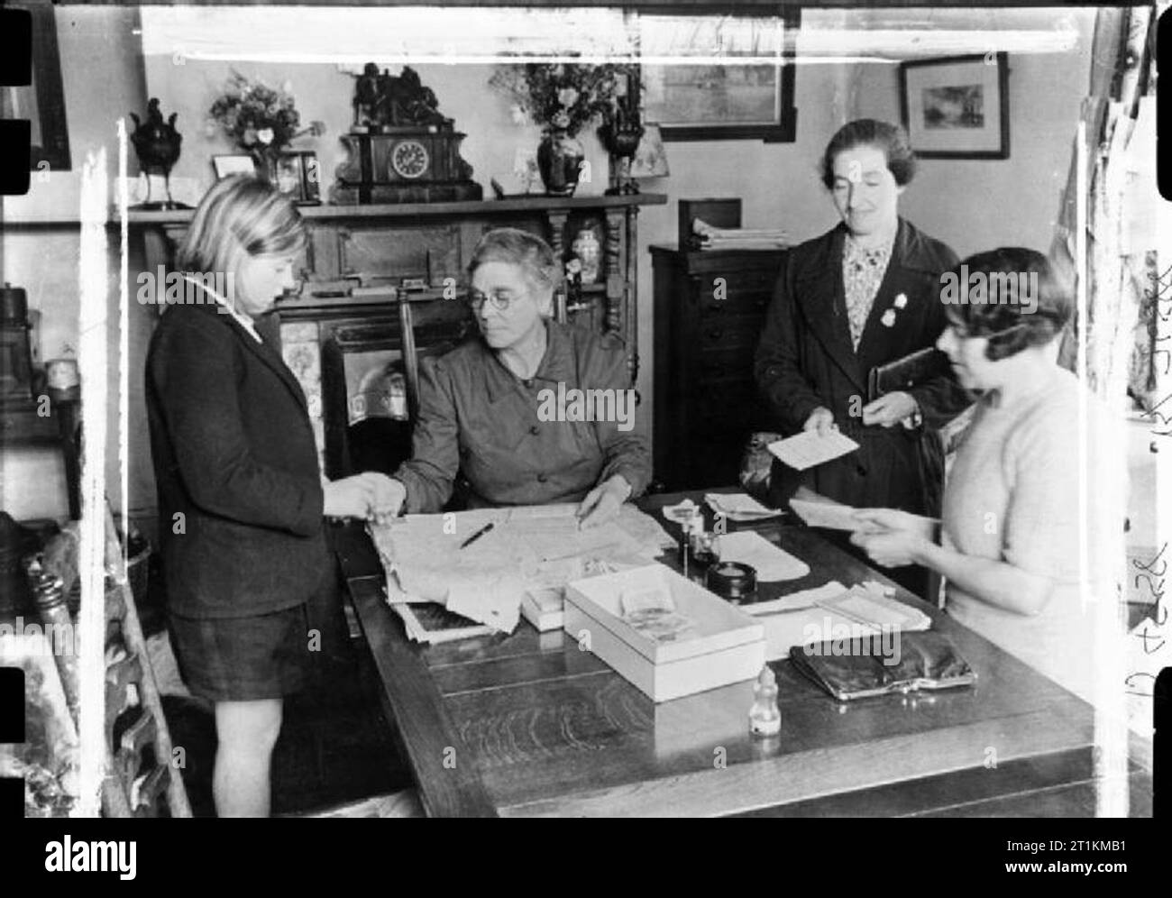 Village d'invasion- la vie quotidienne à Orford, Suffolk, Angleterre, 1941 membres de la Women's Voluntary Service (WVS) vendre des timbres d'épargne dans le domicile d'un de leurs membres, Orford, 1941. Banque D'Images