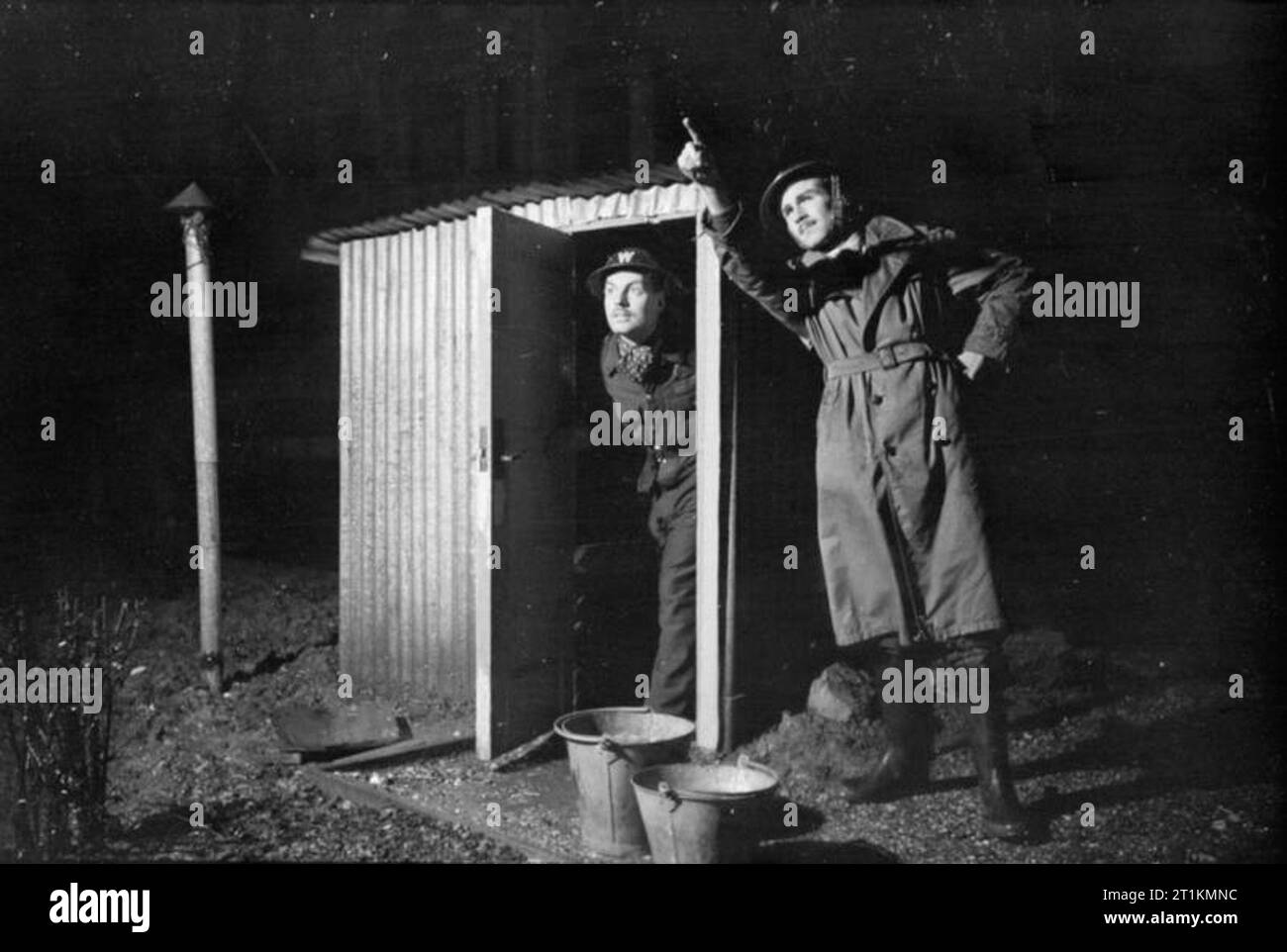 Londres- Afs hommes du feu auxiliaire Service à Londres, C 1940 Raid aérien deux gardes de précautions sont à leur poste ARP. Un préfet est juste à l'intérieur de la cabane en tôle ondulée (qui est construit sur un arbre en béton) tandis que l'autre directeur est orientée vers l'horizon, après avoir repéré un incendie. Banque D'Images