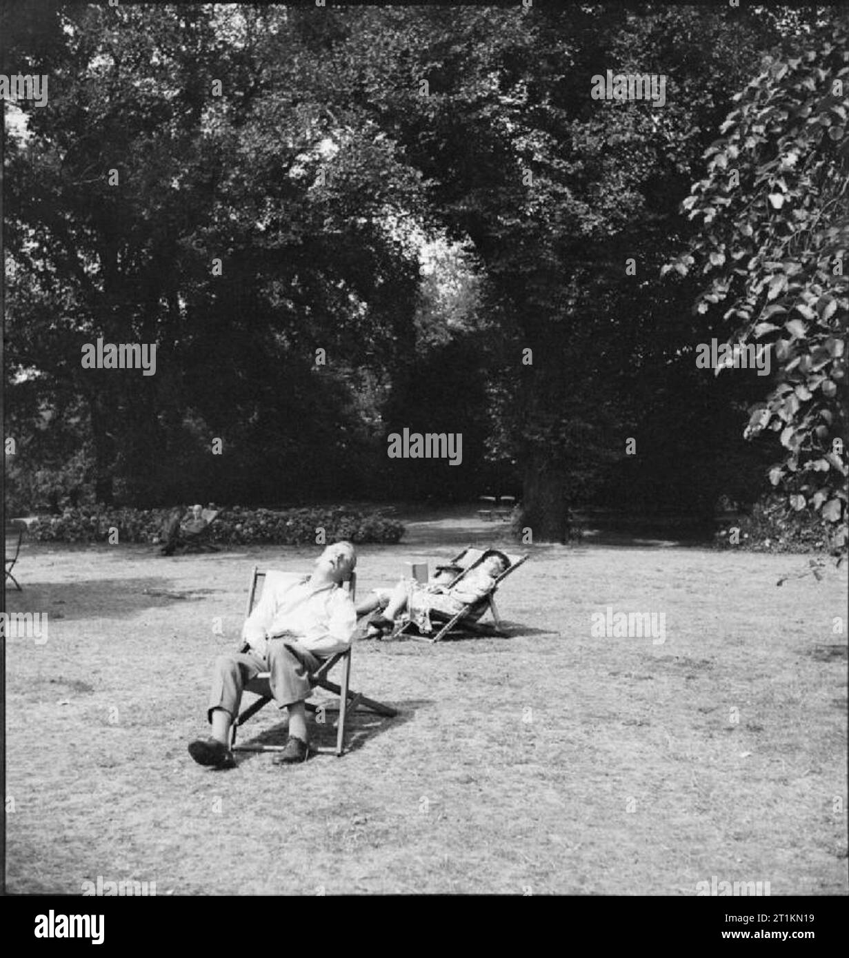 Parcs de Londres- Loisirs et détente au coeur de la ville, Londres, Angleterre, 1943 Trois civils prendre le soleil comme ils dorment au soleil dans le confort des chaises longues à Hyde Park, Londres. Banque D'Images