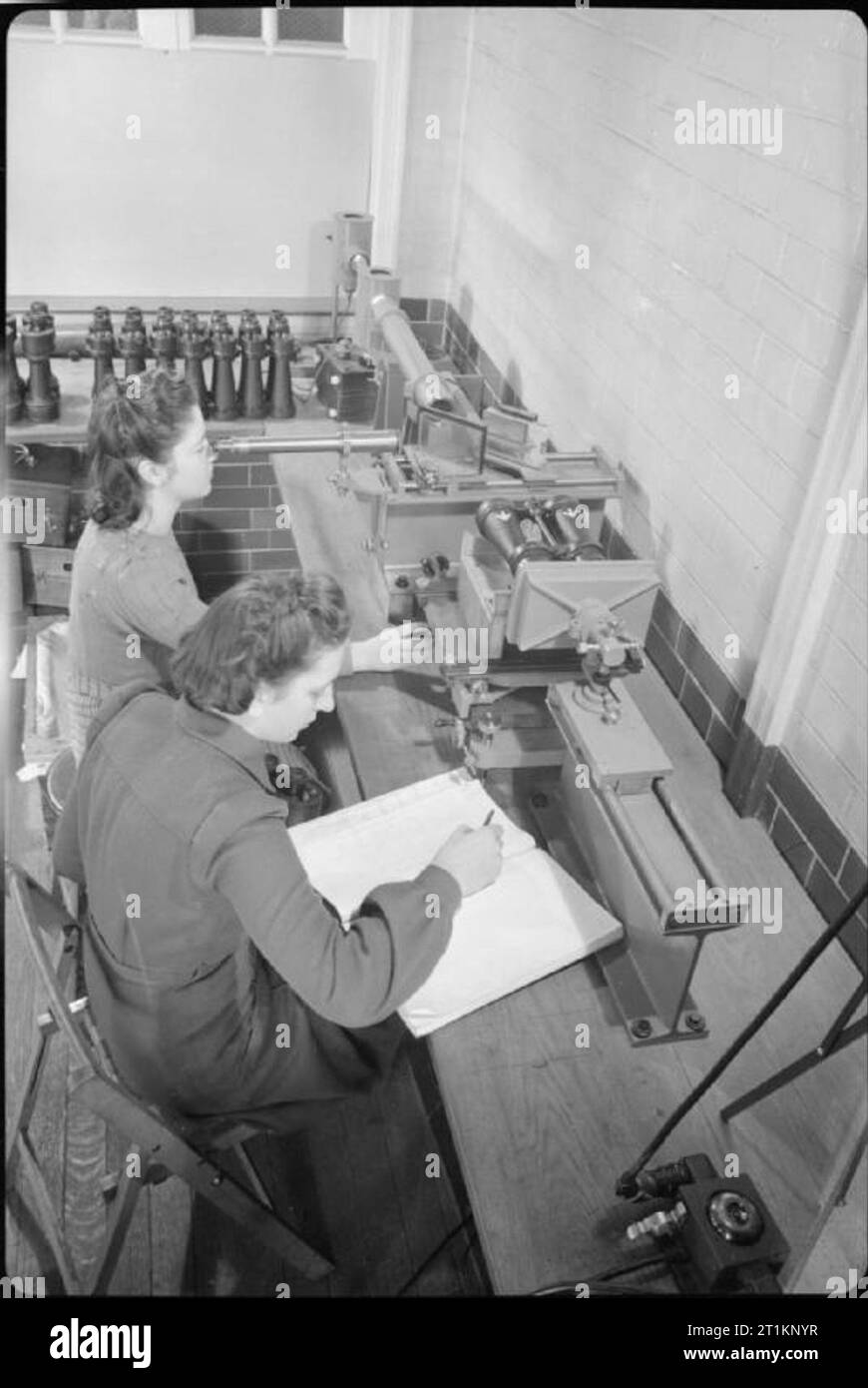 National Physical Laboratory- La science et la technologie en temps de guerre, Teddington, Middlesex, Angleterre, RU, 1944 Deux femmes scientifiques dans l'optique de la Division légère au National Physical Laboratory de Teddington effectuer un test sur le parallélisme à l'aide de jumelles, appareil destiné à la NPL. Selon la légende originale, l'équipement permet 'lectures très rapides à prendre pour déterminer si les deux systèmes optiques dans une paire de jumelles parfaitement parallèles'. Banque D'Images