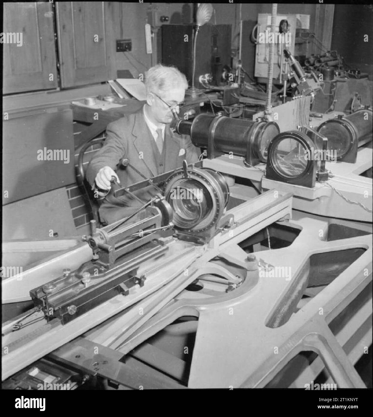 National Physical Laboratory- La science et la technologie en temps de guerre, Teddington, Middlesex, Angleterre, RU, 1944 dans l'optique de la Division légère au National Physical Laboratory, Teddington, un scientifique qui travaille à l'objectif 'universelles' Hilger interféromètre de test. Les principaux travaux de la Section de l'optique se compose d'essais de matériaux optiques et l'examen de l'indice de réfraction différents matériaux. Banque D'Images