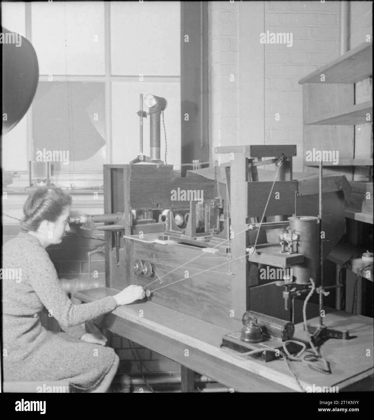 National Physical Laboratory- La science et la technologie en temps de guerre, Teddington, Middlesex, Angleterre, RU, 1944 Un scientifique dans l'optique de la Division légère au National Physical Laboratory de Teddington utilise des appareils spéciaux pour mesurer la réfraction de nuances monté sur un sextant ou d'autres comme instrument d'optique. La légende originale précise que "c'est fait pour s'assurer que les lunettes teintées n'interfèrent pas avec la mesure angulaire correct lorsque le sextant est en cours d'utilisation". Banque D'Images