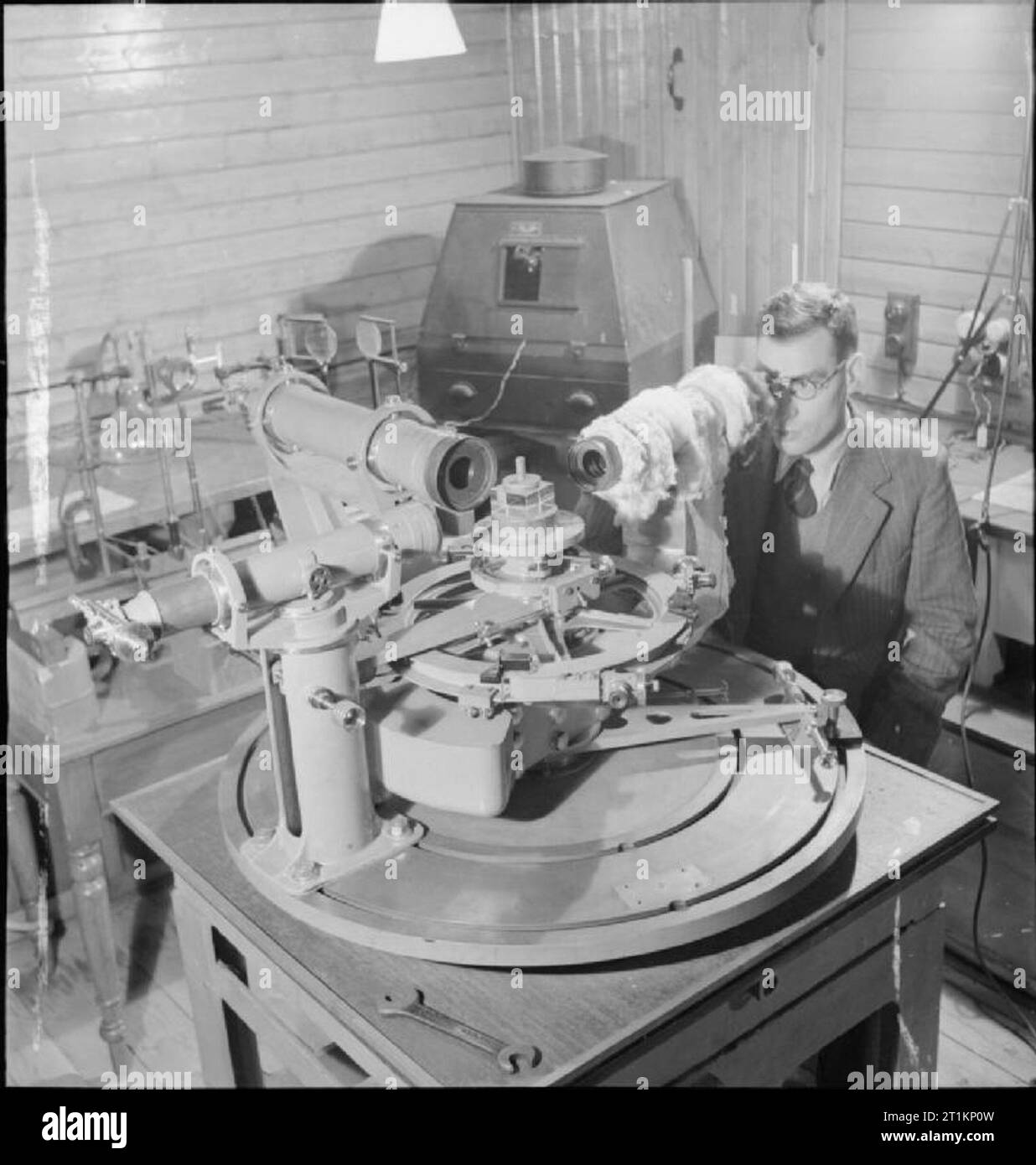 National Physical Laboratory- La science et la technologie en temps de guerre, Teddington, Middlesex, Angleterre, RU, 1944 Un scientifique dans l'optique de la Division légère au National Physical Laboratory, Teddington, regarde à travers un microscope pour lire les mesures prises par le spectromètre à haute précision. Le spectromètre est utilisé pour mesurer les angles de réfraction et de haute précision, et le microscope est nécessaire parce que les gradations utilisé comme sont si bien. Banque D'Images