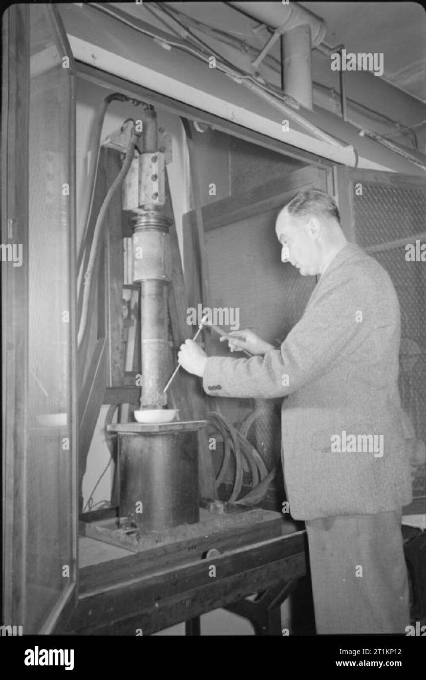 National Physical Laboratory- La science et la technologie en temps de guerre, Teddington, Middlesex, Angleterre, RU, 1944 dans le département de la métallurgie au National Physical Laboratory, un scientifique offre des programmes de recherche sur la méthode de production électrolytique des métaux purs. Les métaux purs sont nécessaires lors de la réalisation d'autres tests dans le développement d'alliages métalliques. Banque D'Images