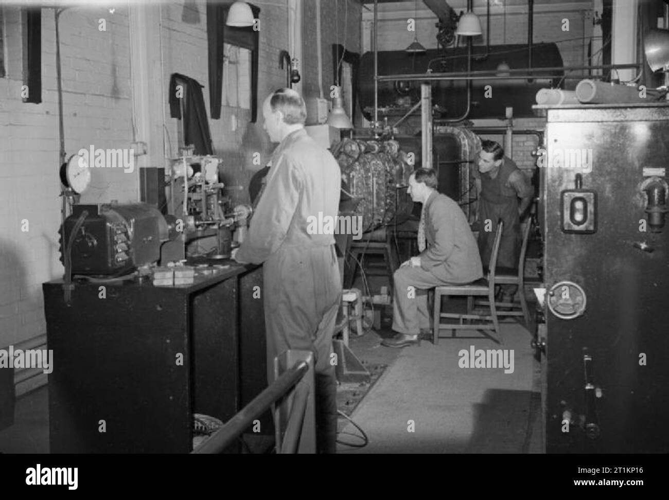 National Physical Laboratory- La science et la technologie en temps de guerre, Teddington, Middlesex, Angleterre, RU, 1944 Une scène dans le département de la recherche du navire National Physical Laboratory de Teddington, montrant Scientifiques au travail l'investigation de l'effet des forces sur un modèle de l'hélice. Le conducteur est assis dans le centre est à la recherche par la fenêtre d'inspection de la partie supérieure du bras de la pression Lithgow tunnel. La légende originale précise que "l'eau dans la partie de l'appareil circulatoire est en mouvement à une vitesse contrôlée et sous une pression contrôlée. L'hélice sous test est connecté Banque D'Images