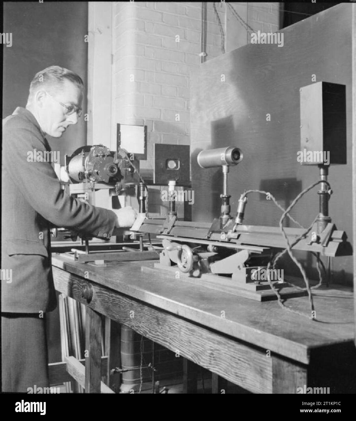 National Physical Laboratory- La science et la technologie en temps de guerre, Teddington, Middlesex, Angleterre, RU, 1944 dans l'optique de la Division légère au National Physical Laboratory de Teddington, un scientifique utilise des appareils spéciaux pour mesurer les échelles et les plages de mise au point de jumelles et télescopes. Banque D'Images