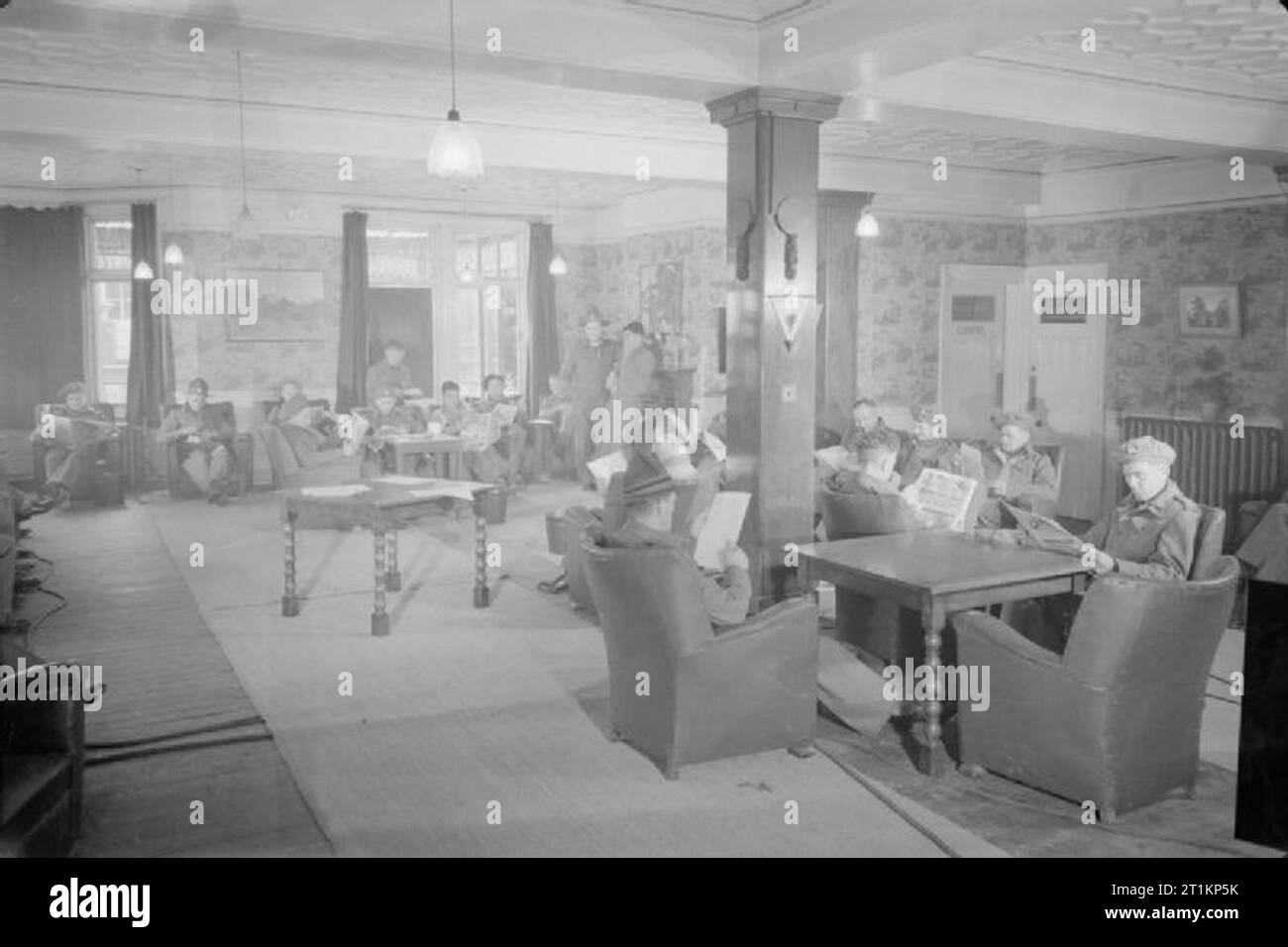 La nouvelle zelande rapatriés arrivent en Angleterre- la vie quotidienne des prisonniers de guerre rapatriés dans la région de Margate, Kent, England, UK, avril 1945 Une vue générale de la salle de repos, ou un salon, à l'hôtel Norfolk, Westcliff, Margate. Nouvelle-zélande nouvellement rapatriés les prisonniers de guerre se détendre et lire le journal dans le cadre confortable. Banque D'Images