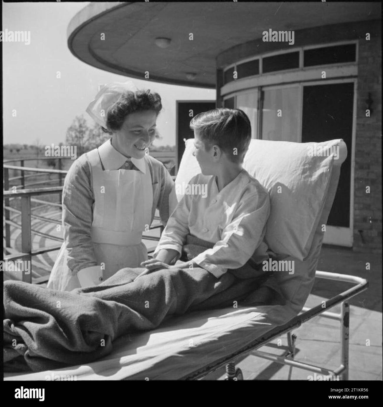 Soins infirmiers Sanatorium- la vie quotidienne à Broomfield Sanatorium, Chelmsford, Essex, Angleterre, 1945 Une infirmière s'entretient avec un jeune patient atteint de tuberculose dans le soleil de plein air 'ward' de Broomfield Sanatorium, Chelmsford. Banque D'Images