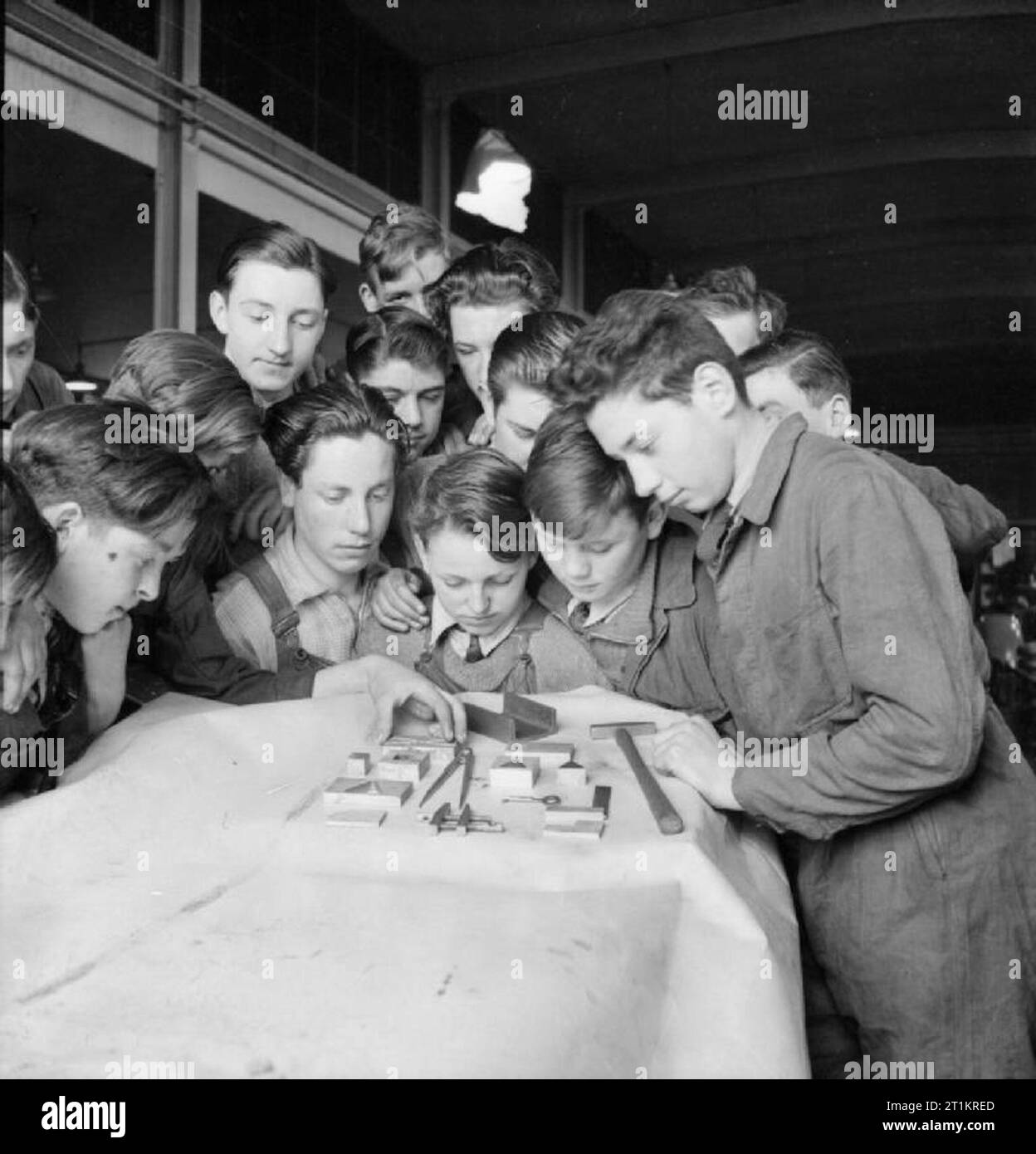 La fabrication de la pompe de l'étrier, Angleterre, RU, 1941 Les garçons à l'école technique jointe à cette usine de la pompe de l'étrier d'examiner certaines des pièces d'essai qu'ils ont réalisés. Les pièces sont correctes à l'intérieur d'un demi-millième de pouce. Les garçons sont formés à cette école, âgés entre 14 et 16. Banque D'Images