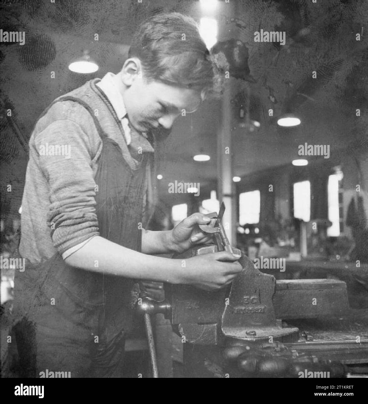 La fabrication de la pompe de l'étrier, Angleterre, RU, 1941 UNE Glaucy, âgée de 15 ans, les mesures d'un carré avec un micromètre à l'école technique jointe à cette usine de la pompe de l'étrier. Il a fait le carré lui-même, et il est correct de l'intérieur d'un millième de pouce. Banque D'Images