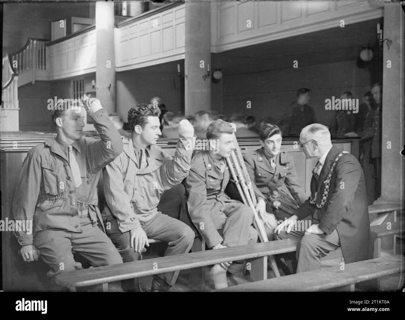 Les soldats américains visiter Wesley's Chapel, Bristol, Gloucestershire, Angleterre, Royaume-Uni, 12 avril 1945 Le maire de Bristol, l'échevin F C Cottrell (droite), conversations à un groupe de soldats américains blessés après un service à John Wesley's Chapel à Bristol. De gauche à droite : le Sergent Lloyd K Bjelland, le sergent Walter Greaney, Circuit Sherman laire et PFC Walter Haid. Les Sgt Bjelland et Greaney ont tous deux des attelles au bras gauche, afin qu'ils s'en tiennent à des angles étranges. Laire Pfc a des béquilles. Banque D'Images