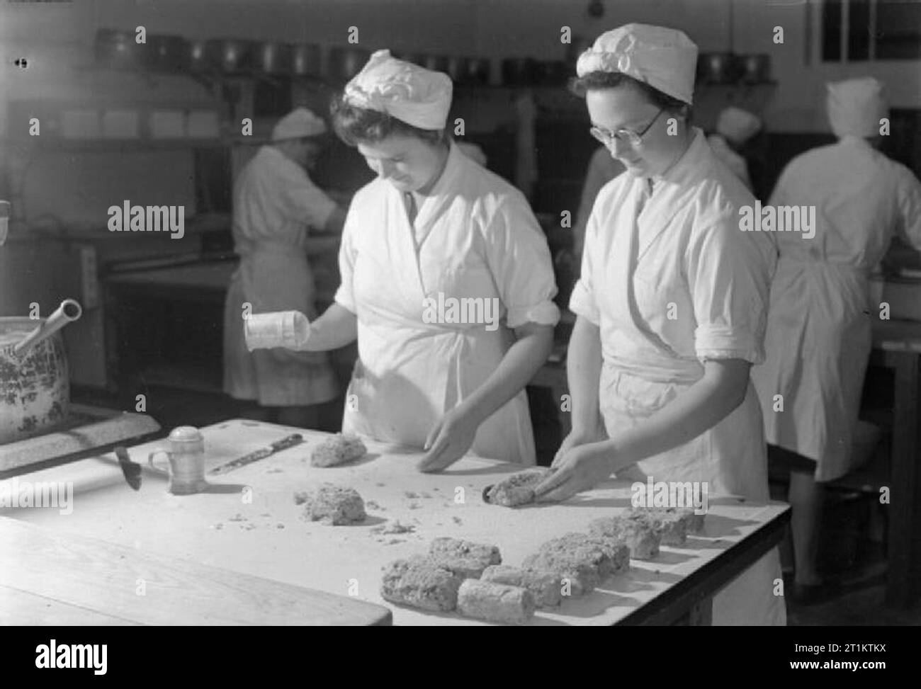 Ils s'entraînent à être cuisiniers- des cours de cuisine au collège national de formation de l'enseignement ménager, Westminster, Londres, Angleterre, RU, 1944 Deux élèves de l'École nationale des sciences domestiques faire rissoles dans l'une des grandes cuisines du collège. Selon la légende originale : "Ils nous ont ajouté le chou déshydratée, la pomme de terre et carotte pour le mélange. Cette école s'engage à diverses expériences pour le ministère de l'alimentation'. Banque D'Images