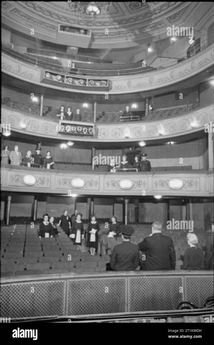 Théâtre de guerre- in London, Angleterre, Royaume-Uni, août 1943, M. Cooke, gérant du cinéma au Lyric Theatre sur Shaftesbury Avenue, (au centre au premier plan) coup de sifflet pour appeler le personnel du théâtre à roll call. Les membres du personnel de l'assemblage dans les stalles, cercle, cercle supérieur et galerie. S'il y a loin du personnel, puis le reste du personnel sera organisé pour combler les lacunes. Banque D'Images