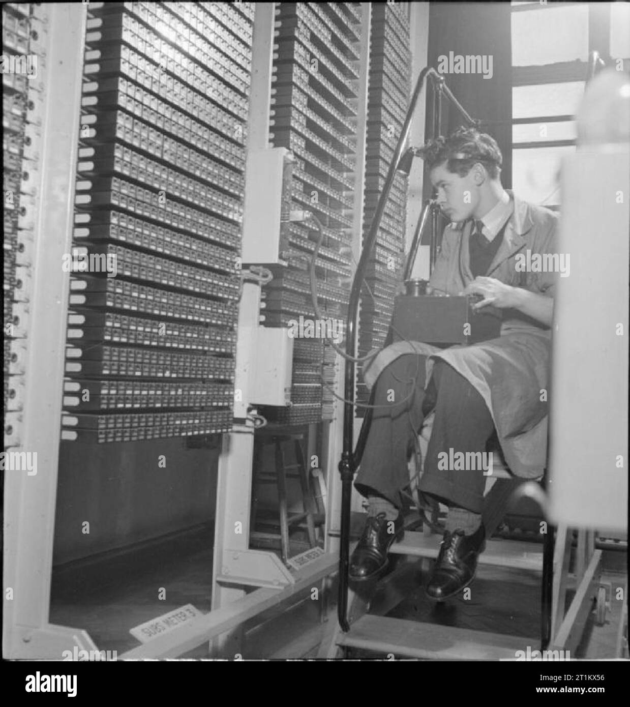 L'échange téléphonique automatique- Communications en temps de guerre, Londres, Angleterre, RU, 1945 à un échange téléphonique automatique à Londres, un ingénieur teste les compteurs des abonnés afin de s'assurer que tout fonctionne correctement. Ces compteurs sont déclenchés lorsqu'un appel 'boucle' (c'est, lorsque les connexions ont été faites et la conversation peut avoir lieu) est terminé, et les abonnés sont alors facturés en conséquence. Banque D'Images