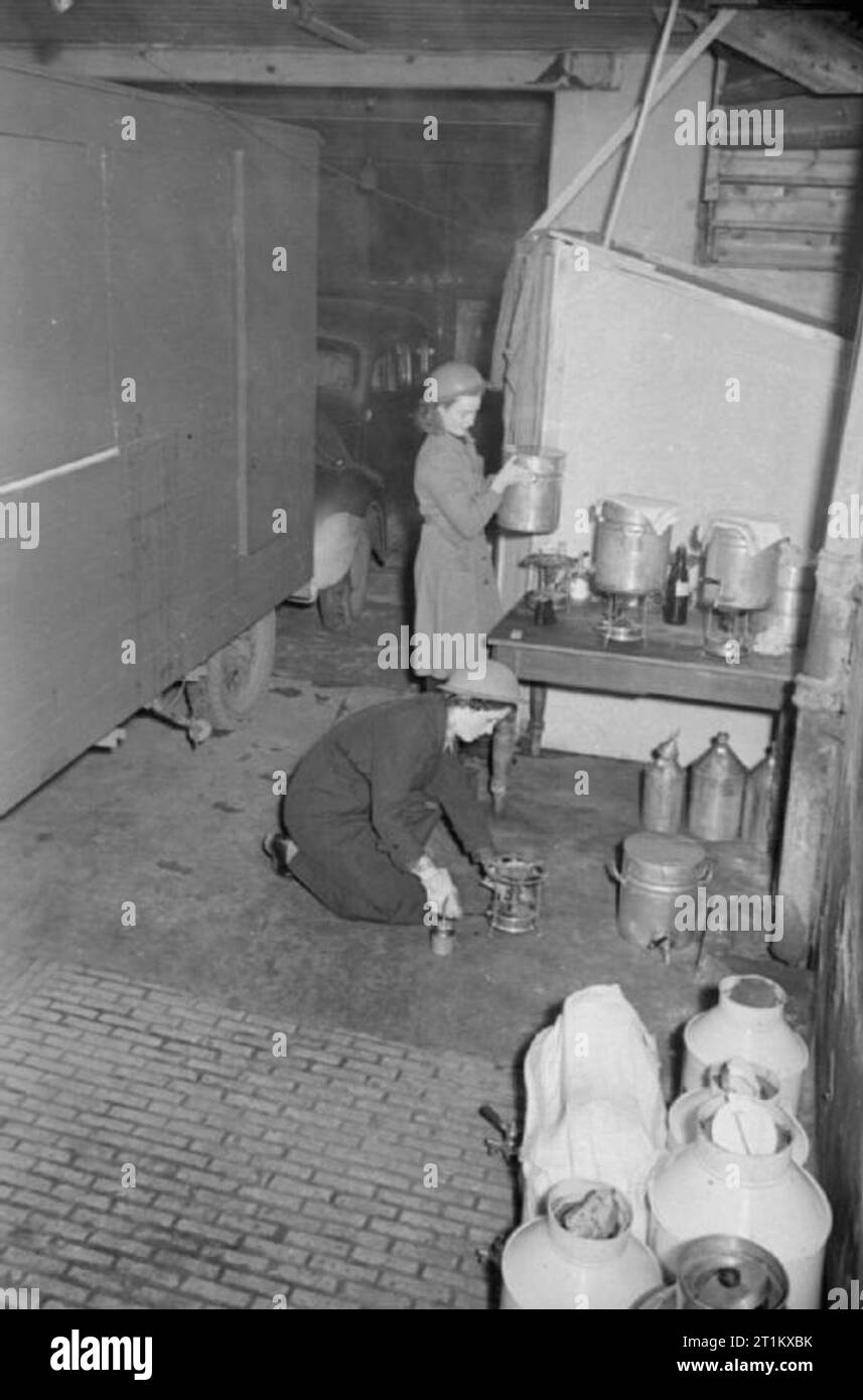 Cantine Blitz- les femmes du Women's Voluntary Service Exécuter une cantine mobile à Londres, Angleterre, 1941, il est 2 h 45 et à la patience 'Boo' Marque et Rachel Bingham se préparent à leur cantine le WVS Canteen Service depot en 1941. Rachel allume une cuisinière de Primus, alors que Boo fait de thé avant de le verser dans de grandes urnes thermos prêt pour servir à l'arrivée à leur destination. Banque D'Images