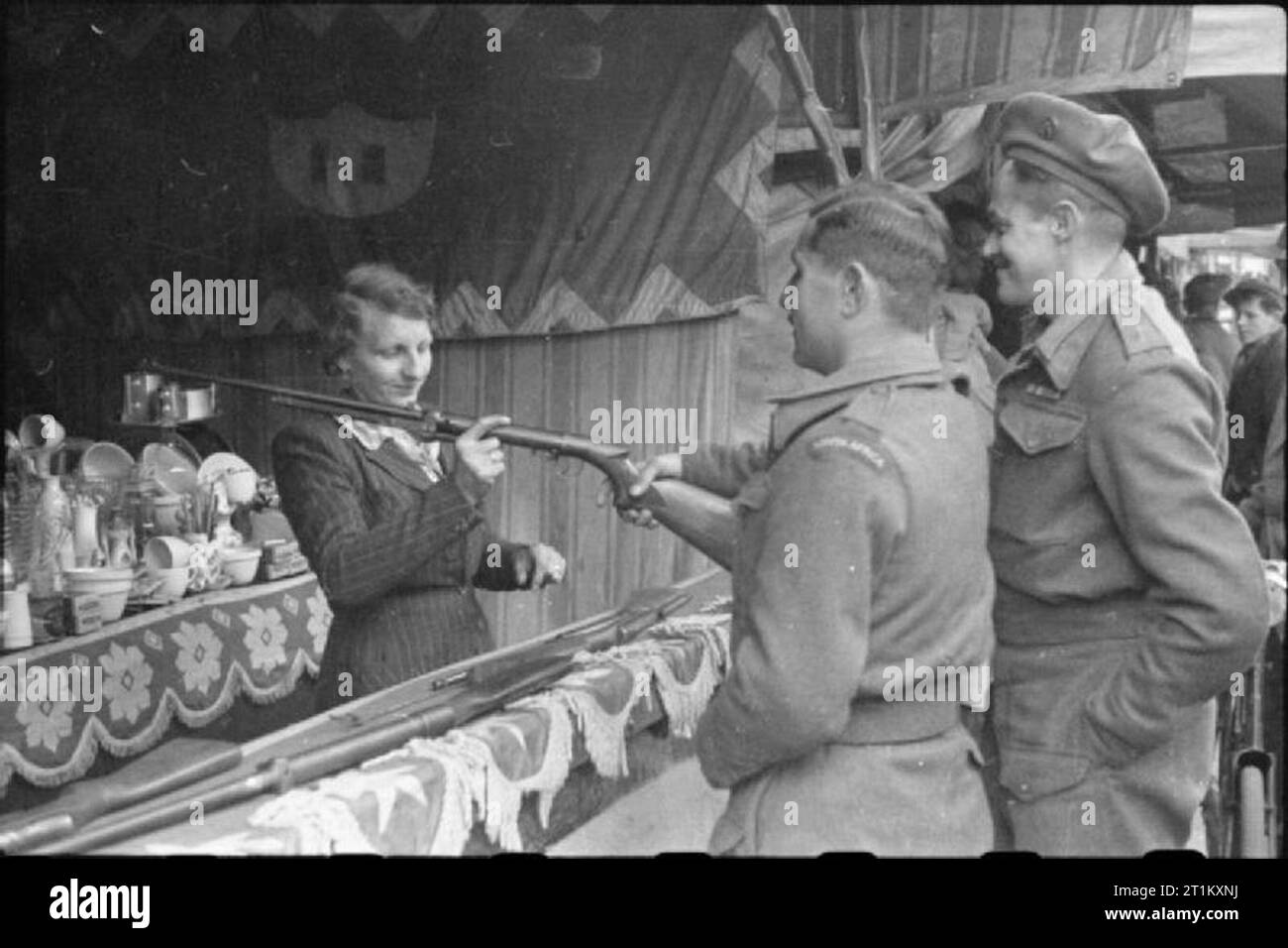 Marché de Boston- le marché de pays et peut juste, Boston, Lincolnshire, Angleterre, RU, 1945 Deux soldats sud-africains tenter votre chance à un jeu de tir à la May Fair, Boston, Lincolnshire. Divers articles de vaisselle utilitaire peut être vu sur une table derrière le comptoir, remis dans le prix si la cible est touchée. Banque D'Images