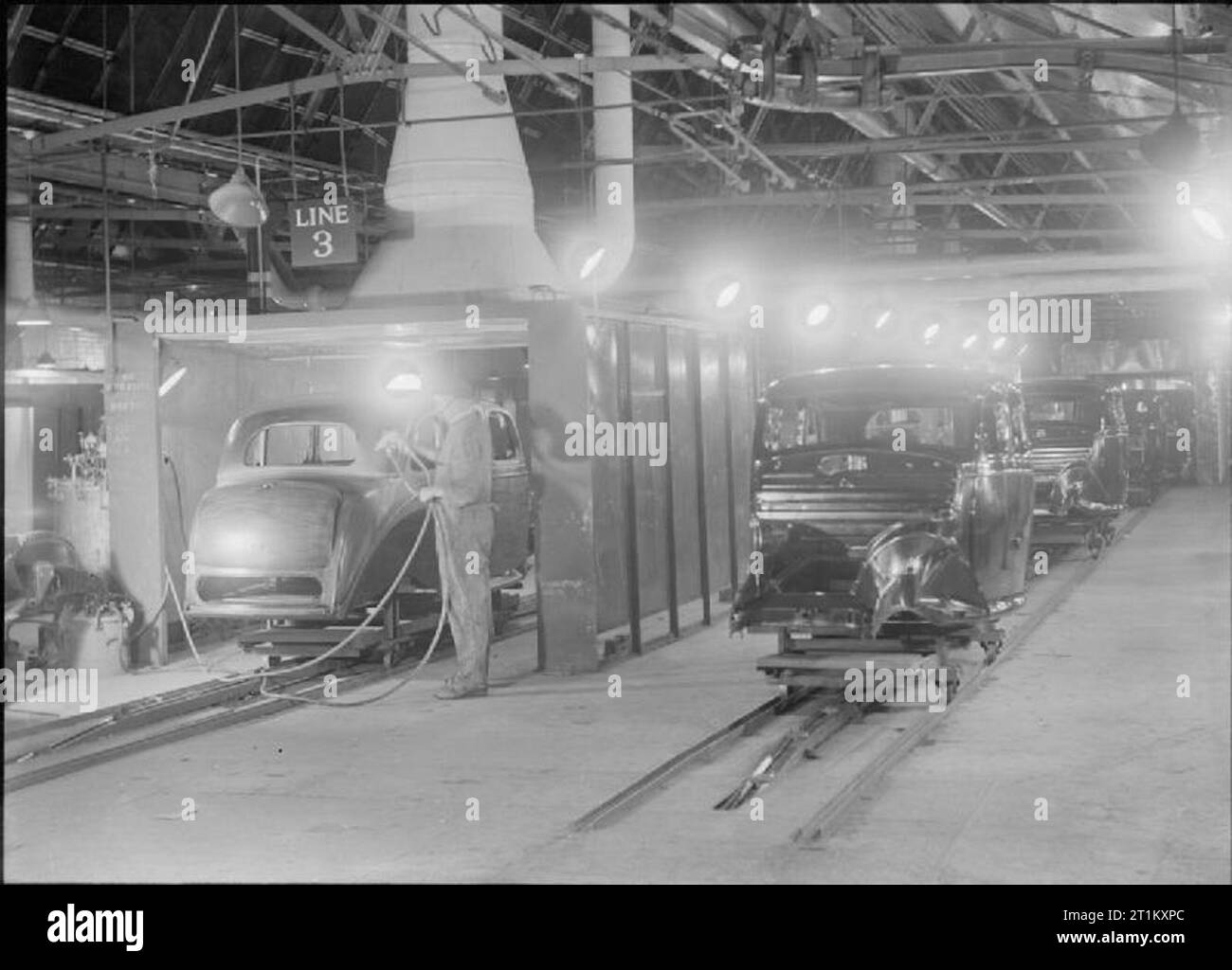 La Grande-Bretagne s'appuie les wagons légers- l'industrie automobile britannique, UK, 1945 Une vue générale de l'atelier de peinture sur une voiture usine, quelque part en Grande-Bretagne. Selon la légende originale, le véhicule sur la gauche dans une cabine de 'commence sur un 16 heures de voyage, recevront 3 couches de remplissage, 4 de primaire, et 2 de la cellulose, passera par la longue et de séchage fours de trempe, et de retour, comme les corps sur la droite, prêt pour le découpage et l'assemblage final du corps'. Banque D'Images