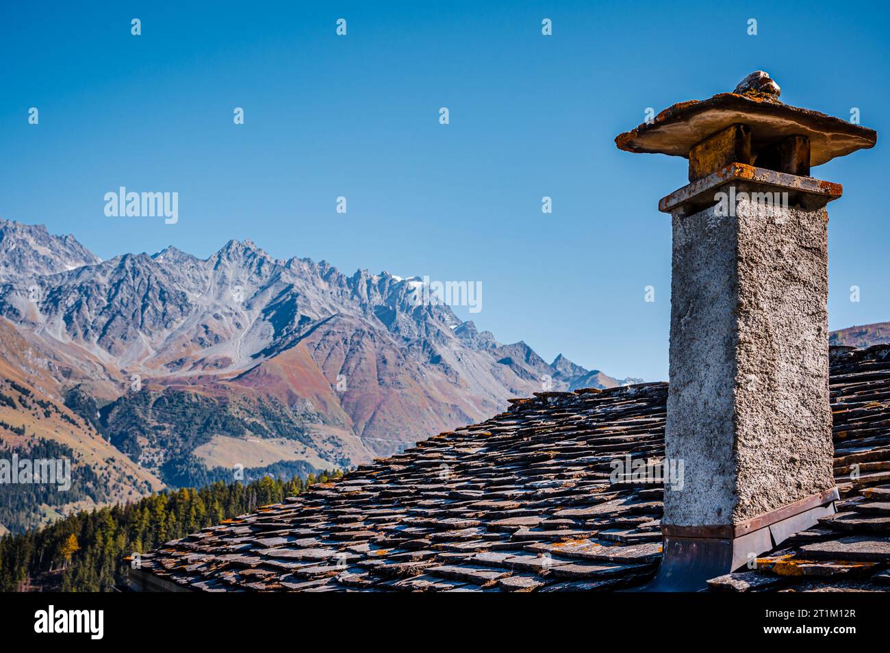 Montagne, cheminée et toit de tuiles de pierre en automne. Liddes, Canton du Valais, Suisse. Banque D'Images
