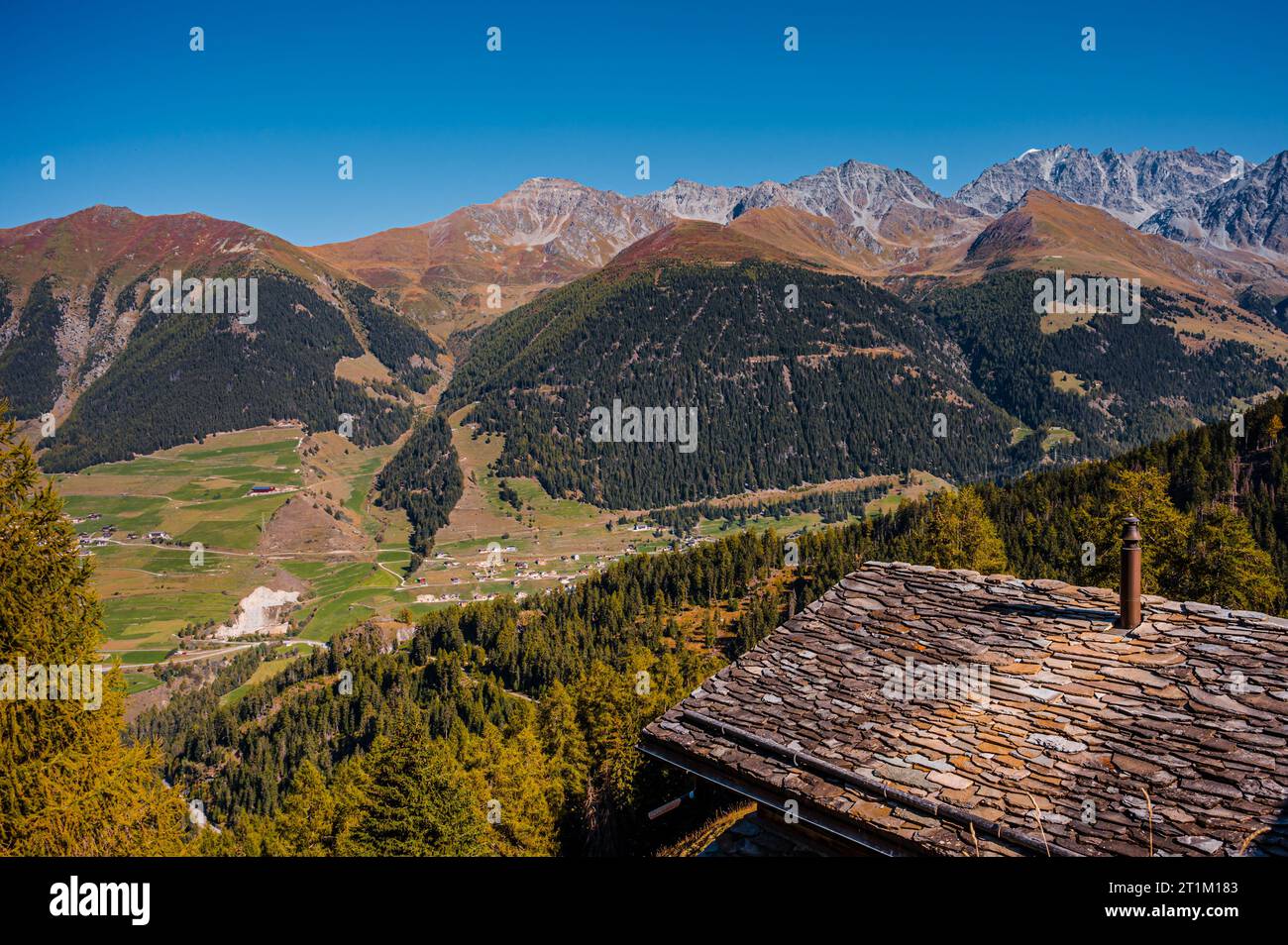 Montagne, cheminée et toit de tuiles de pierre en automne. Liddes, Canton du Valais, Suisse. Banque D'Images