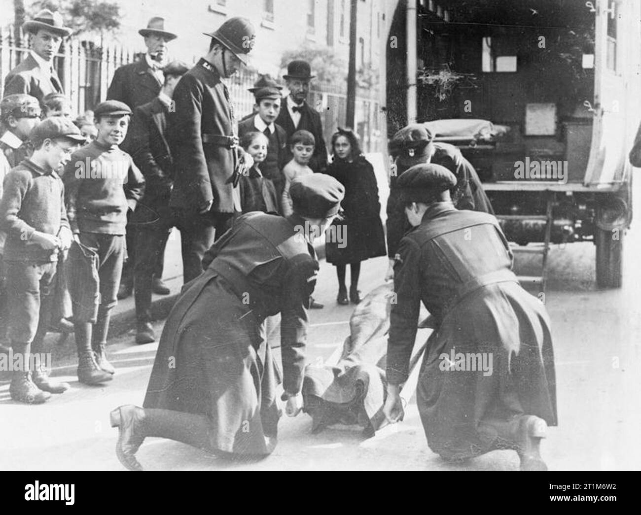 Ministère de l'information Première Guerre mondiale Collection officielle, le London County Council femme ambulanciers levée garçon blessé sur brancard. Banque D'Images