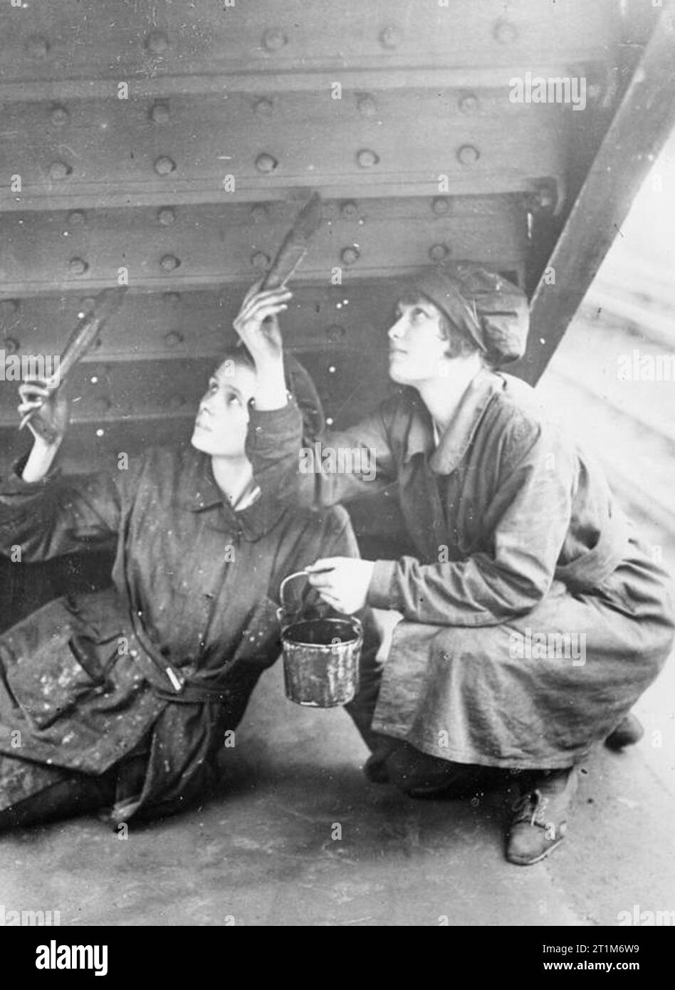 Ministère de l'information collection officielle de la Première Guerre mondiale femmes peintres au travail sur les marches de la gare ferroviaire de District Hammersmith. Banque D'Images