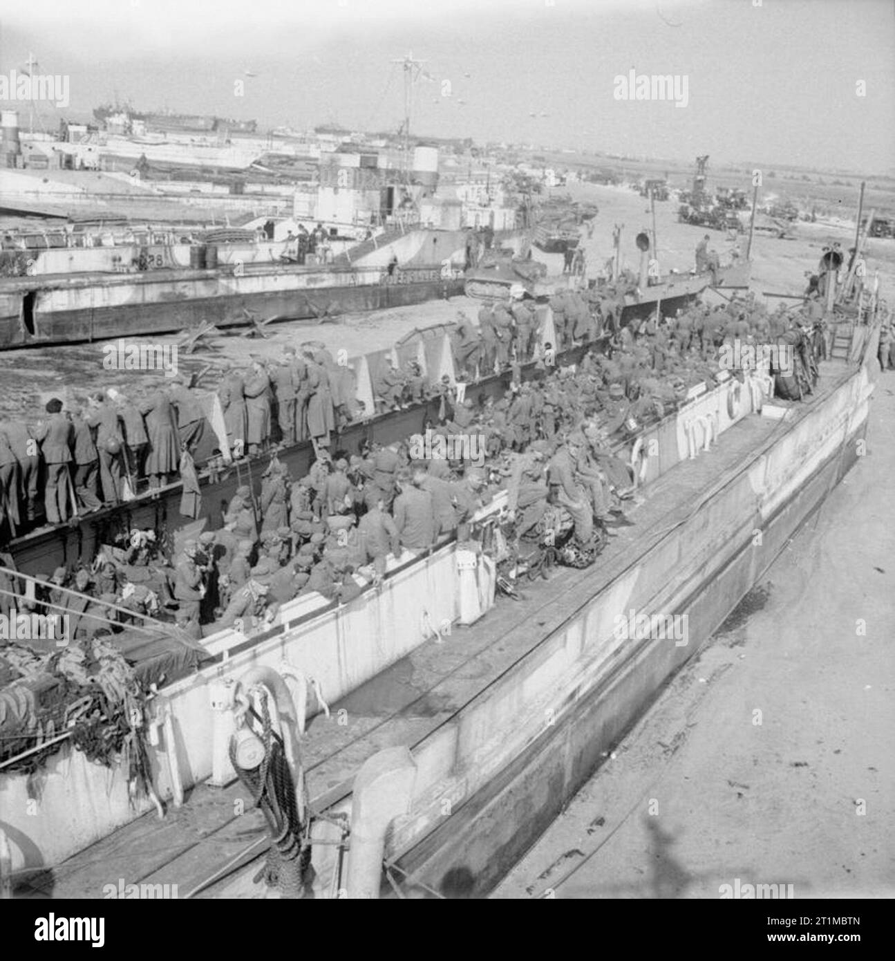 L'armée britannique dans la campagne de Normandie 1944 prisonniers de guerre allemands détenus dans un débarquement de chars a échoué sur la plage verte de la boîte d'or, salon, 7 juin 1944. Dans l'arrière-plan est de LCT 886 qui a été fortement endommagé sur D-Day. Banque D'Images