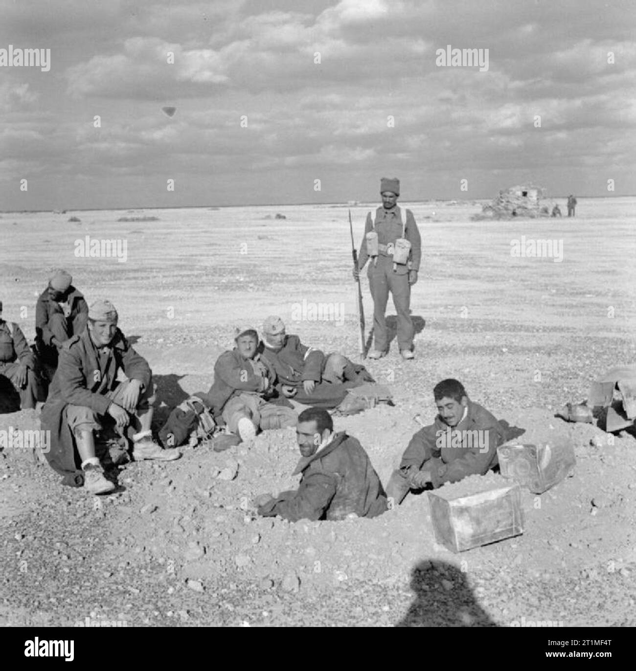 Les forces indiennes en Afrique du Nord pendant la Seconde Guerre mondiale, un soldat indien guards un groupe de prisonniers italiens près d'El Adem aérodrome, au cours de la poursuite de forces de l'axe vers l'ouest après le soulagement de Tobrouk. Banque D'Images