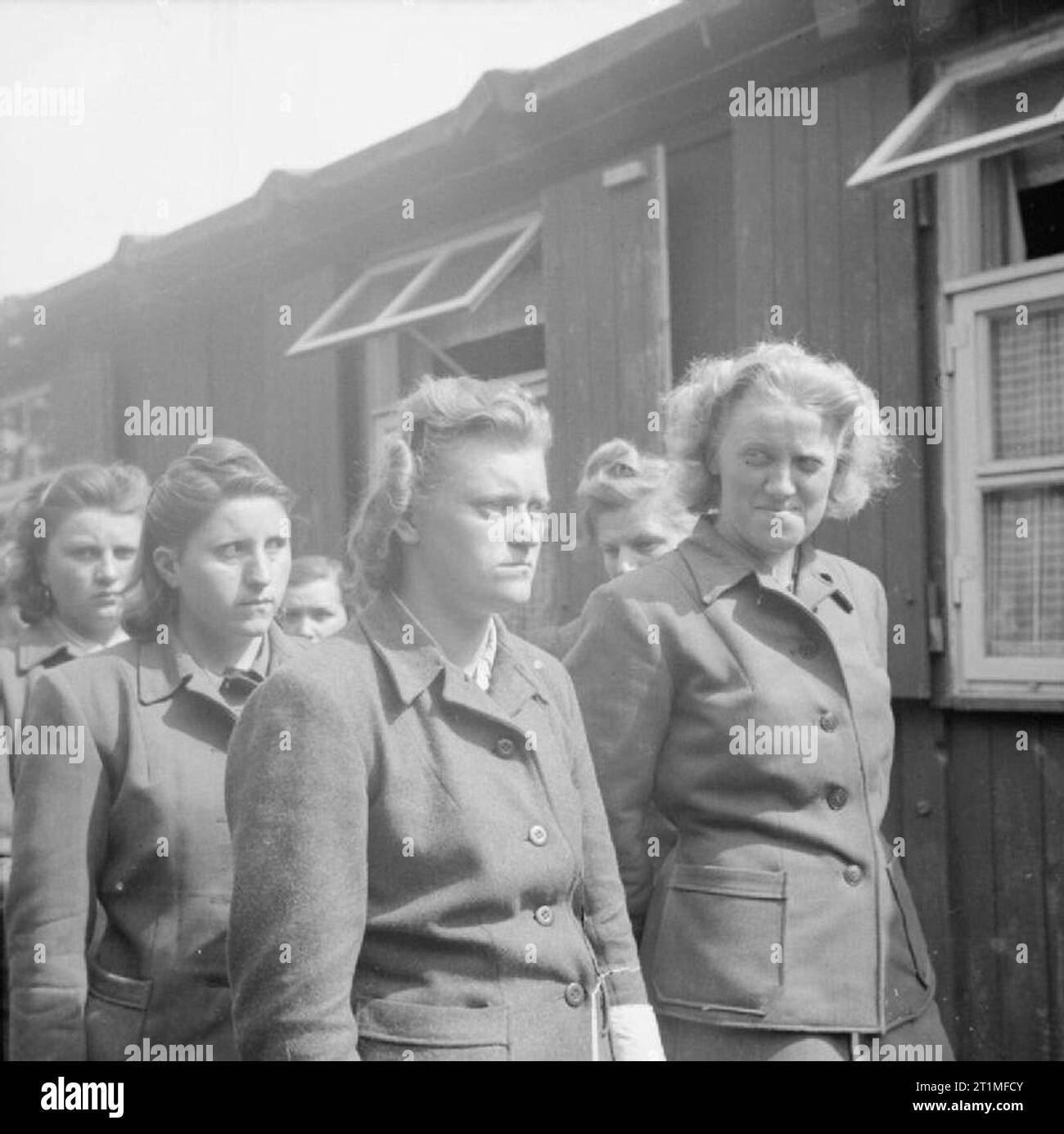 Libération du camp de concentration de Bergen-belsen, avril 1945 des femmes SS gardiennes du camp sont défilées pour travailler à l'enlèvement des morts. Parmi les femmes figurent Hildegard Kanbach (première à partir de la gauche), Irene Haschke (centre, troisième à partir de la droite), la gardienne principale, Elisabeth Volkenrath (deuxième à partir de la droite, partiellement cachée) et Herta Bothe (première à partir de la droite). Banque D'Images