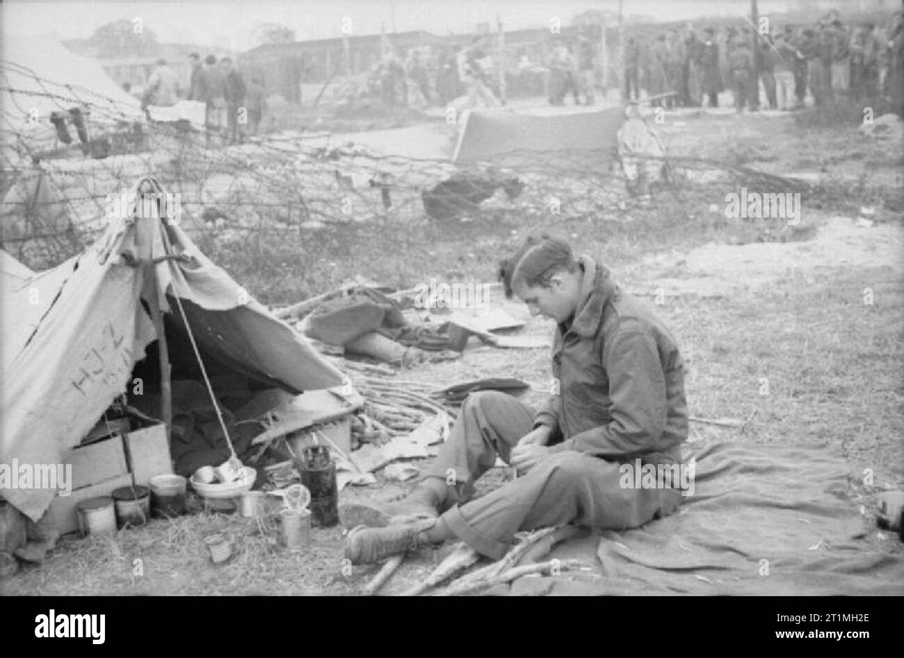 Libération du Stalag 7a, l'Allemagne, un ancien prisonnier de guerre à l'extérieur de son bivouac de fortune dans le camp près de l'enceinte des casernes. Banque D'Images