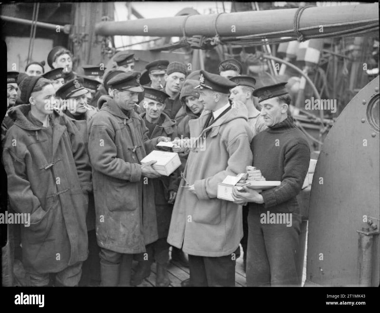 La Royal Navy pendant la Seconde Guerre mondiale, le Lieutenant H L R.Choppin remettant un don de gratuitement des cigarettes à partir de la Ligue d'outre-mer Fonds tabac, ainsi que les cartes d'accusé, à son équipage. Banque D'Images