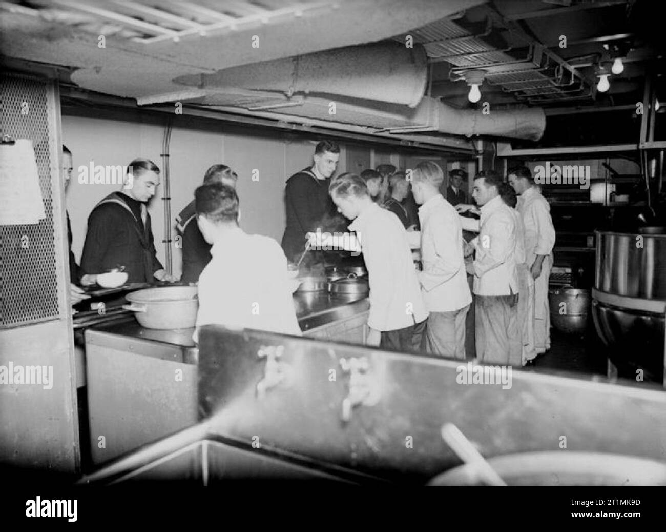 La Royal Navy pendant la Seconde Guerre mondiale à bord de porte-avions d'escorte HMS DASHER à Liverpool. De l'intérieur de la cuisine de marins peuvent être vus d'être servi avec le dîner à la cafétéria du comptoir. Le navire a été l'un des premiers navires de guerre britanniques à l'américaine ont essayé de remplacer la tradition cafétérias méthode de jouer. Banque D'Images