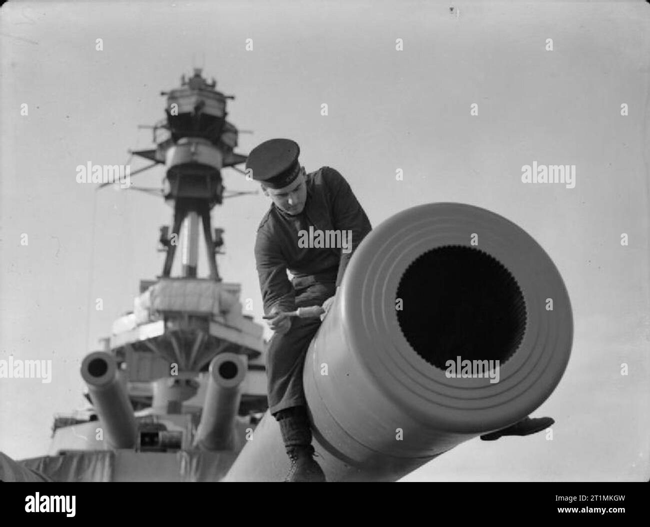 La Royal Navy pendant la Seconde Guerre mondiale un score de marine à califourchon sur le canon d'une arme à feu 15 pouces Mark I à bord du cuirassé HMS REVENGE. Il peint le fourreau. Le polygroove la spoliation pouvez cleary est visible à l'intérieur les armes. Banque D'Images