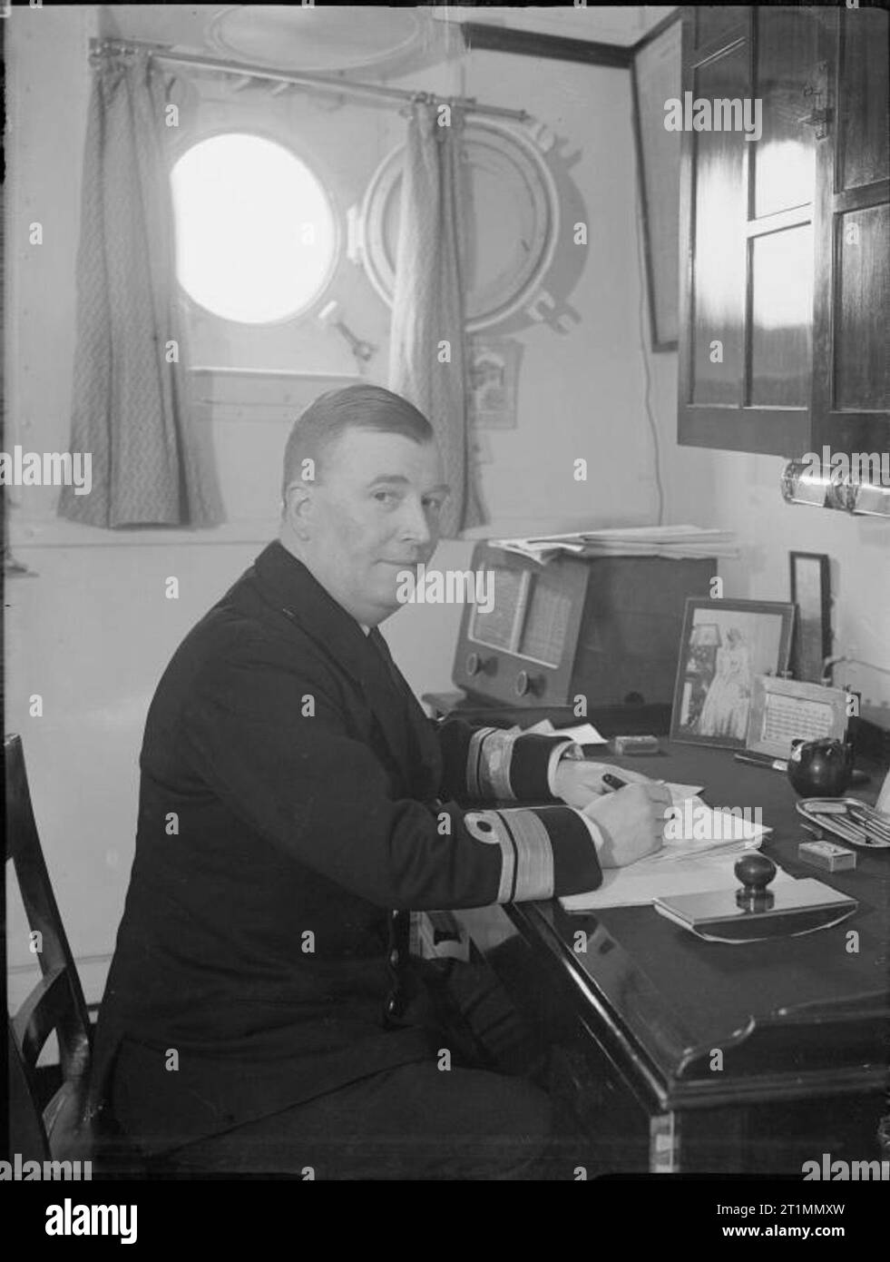 La Royal Navy pendant la Seconde Guerre mondiale, le Vice-amiral R L Burnett, CB, DSO, OBE, dans sa cabine à bord du HMS BELFAST tandis qu'à Scapa Flow. (NB Il porte des rayures de l'amiral arrière). L'amiral Burnett était commandant de l'cruiser force qui a joué un grand rôle dans le naufrage du cuirassé allemand Scharnhorst, le 26 décembre 1943. Banque D'Images