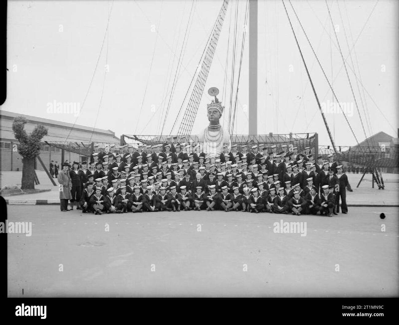 La Royal Navy pendant la Seconde Guerre mondiale M. W J Jordanie, le Haut Commissaire de la Nouvelle-Zélande, avec un très grand groupe de marins de la Nouvelle-Zélande à l'établissement d'instruction navale HMS Ganges, Shotley. Ils sont se tenait en face de la tête de mât et figure de proue du HMS Ganges. Banque D'Images