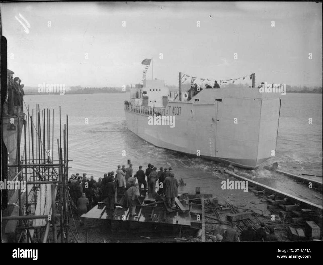 La Royal Navy pendant la Seconde Guerre mondiale, à l'IGS 4037 (plus tard renommé HMS REMPART), le premier d'une nouvelle classe de LCT(8), la descente des façons après avoir été lancé par le commandant Earl Beatty, DSC, RN. Regardez les travailleurs en premier plan à la Cour Kelliebank de Sir William Arrol & Co, Ltd. à Peterlee, en Écosse. Banque D'Images