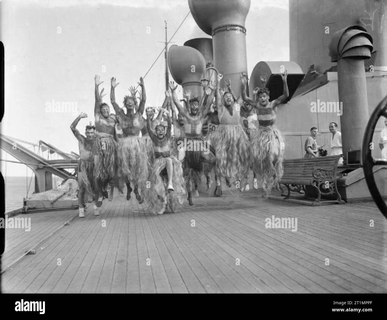 La Royal Navy pendant la Seconde Guerre mondiale, les marins et l'herbe étaient noircis portant des jupes à faire ce que peut être leur impression d'une danse Maori au cours de la cérémonie de "Crossing the Line' au cours d'un convoi de troupes africaines. Banque D'Images