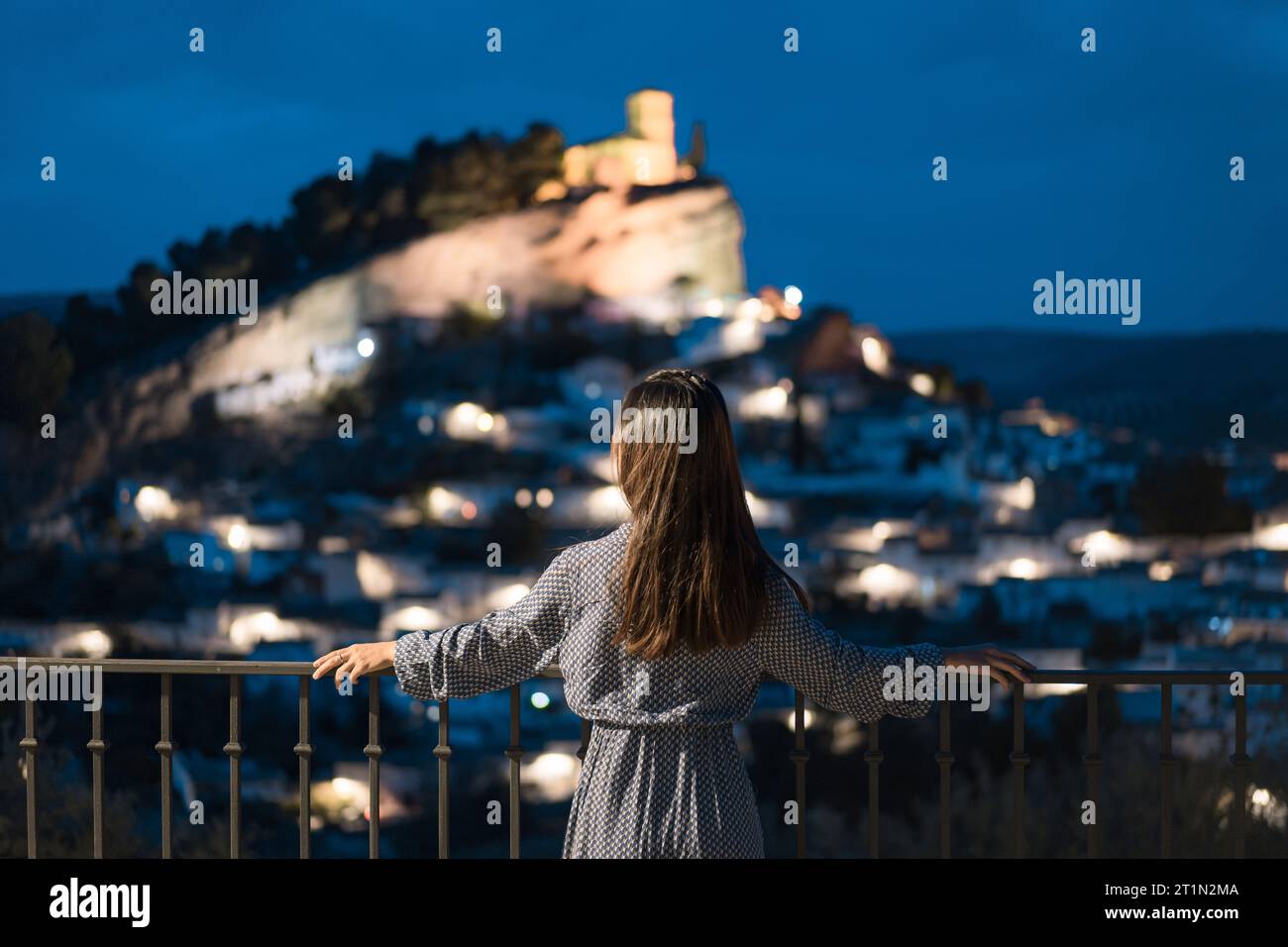 Femme en voyage, femme asiatique en robe bleue regardant la vieille ville de Montefrío la nuit à Grenade, Espagne Banque D'Images