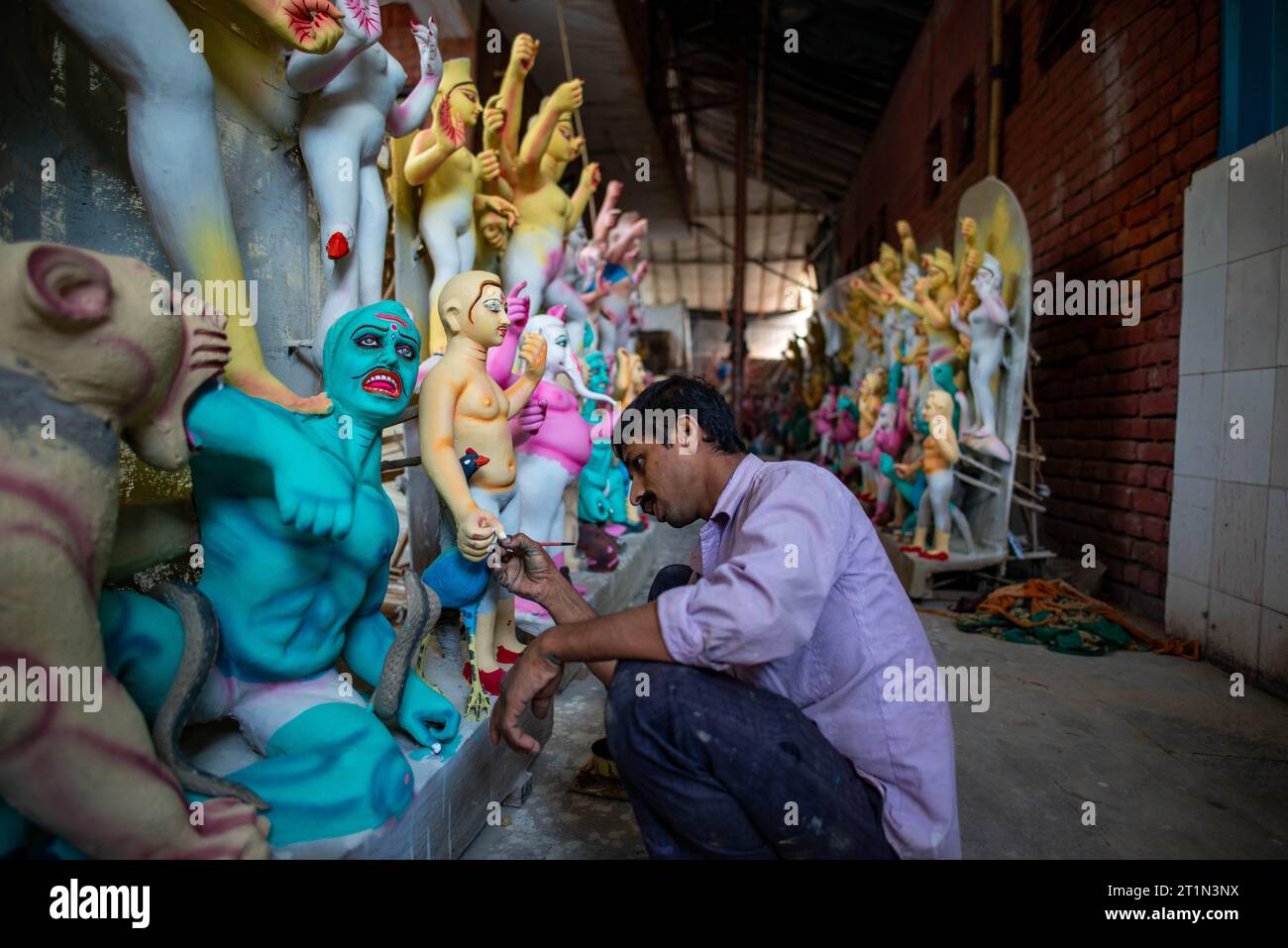 Un artiste vu donner la touche finale à l'idole d'argile de la déesse Durga pour le prochain festival Durga Puja, au temple Sarojini Nagar Kalibari. Durga Puja est un festival hindou célébré principalement dans le Bengale occidental et par les communautés bengales du monde entier. C'est une célébration de plusieurs jours dédiée à la déesse Durga, symbolisant le pouvoir féminin divin et la victoire du bien sur le mal. Banque D'Images