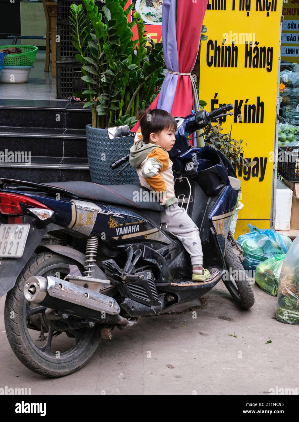 Cat Ba, Vietnam. Jeune garçon explorant la moto. Banque D'Images