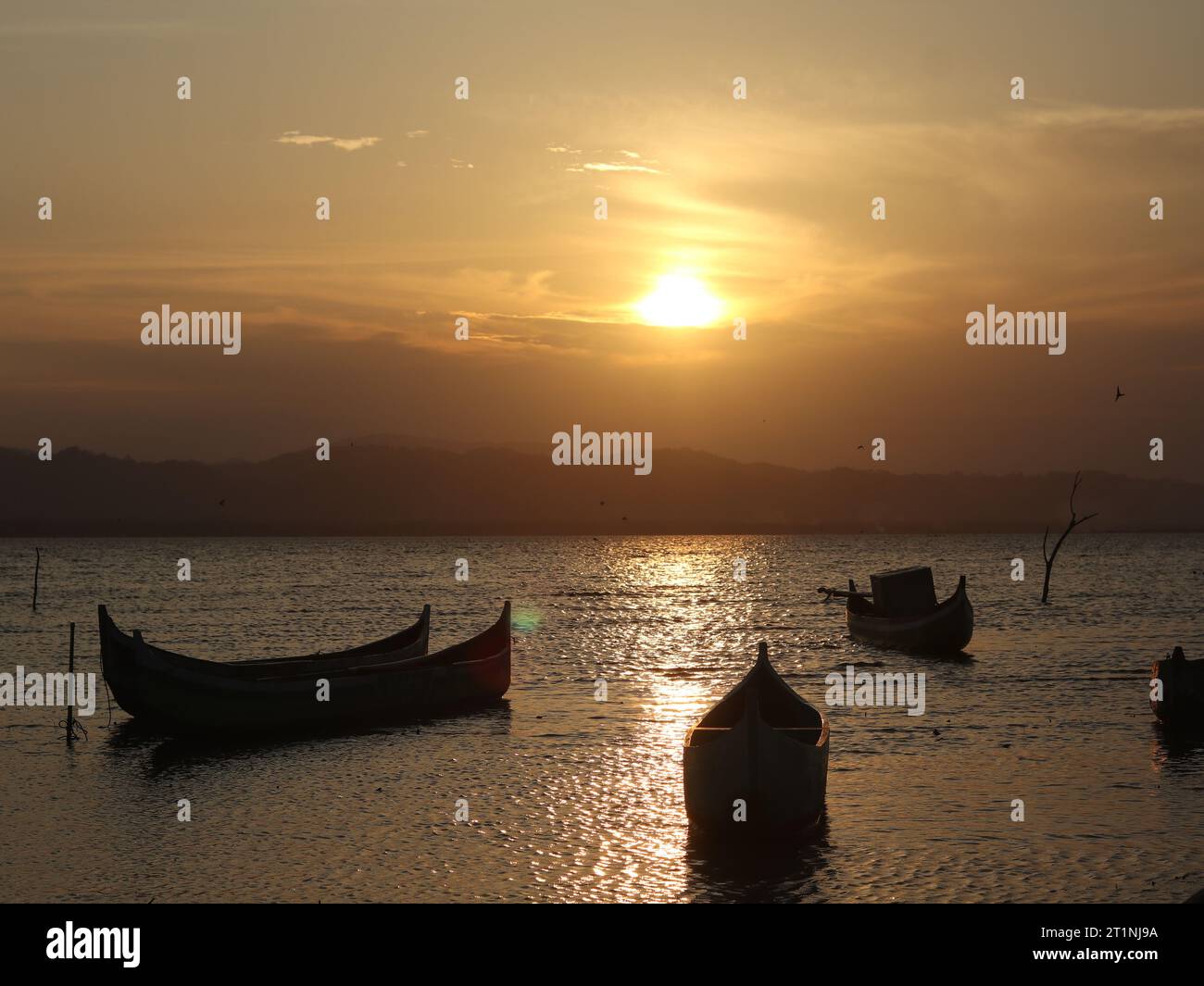 Silhouette d'un bateau dans la mer au coucher du soleil Banque D'Images